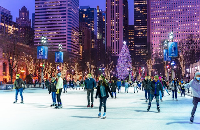 People are enjoying ice skating during beautiful winter night in Millennium Park Ice Rink