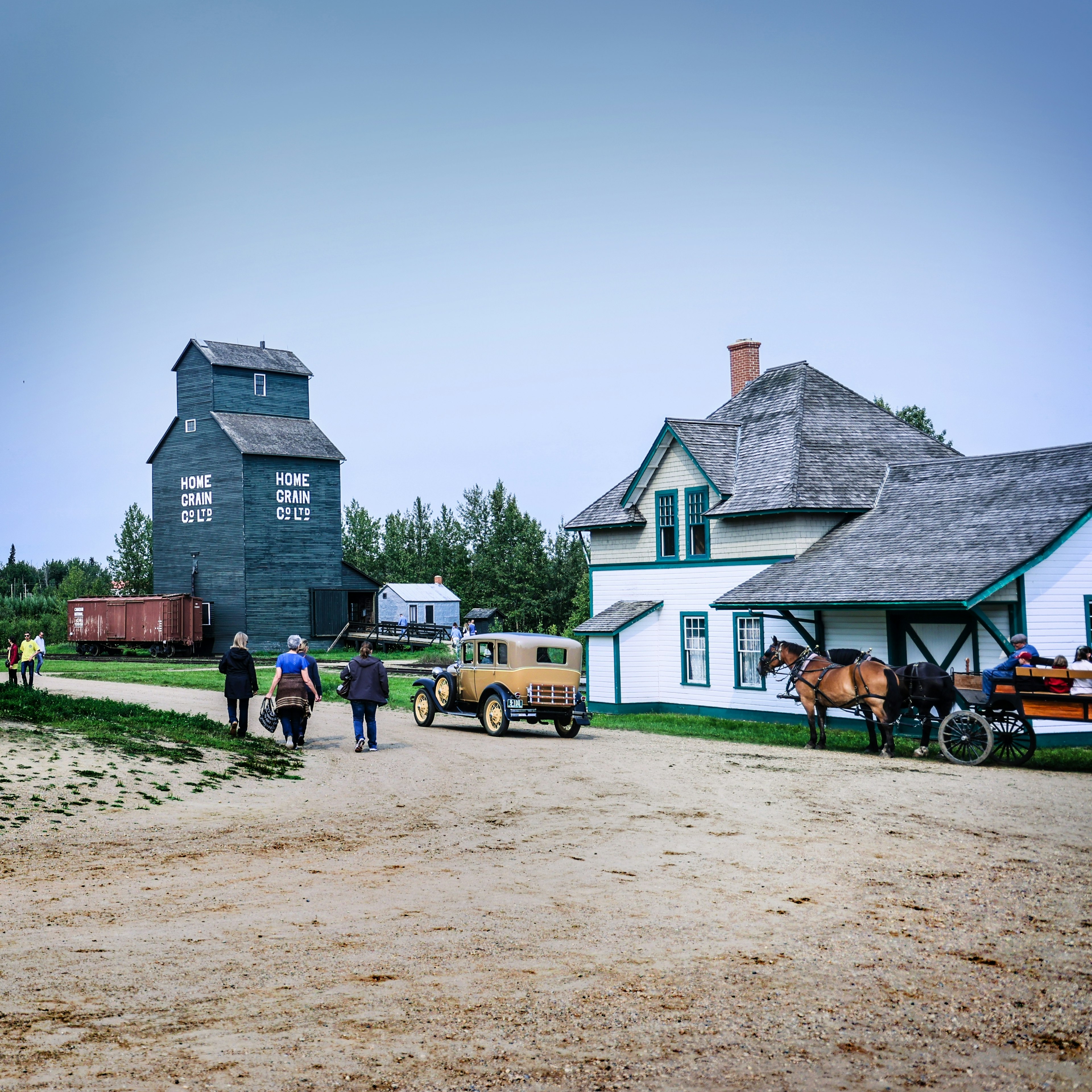 An old-fashioned rural village with low-rise wooden buildings and a horse and cart