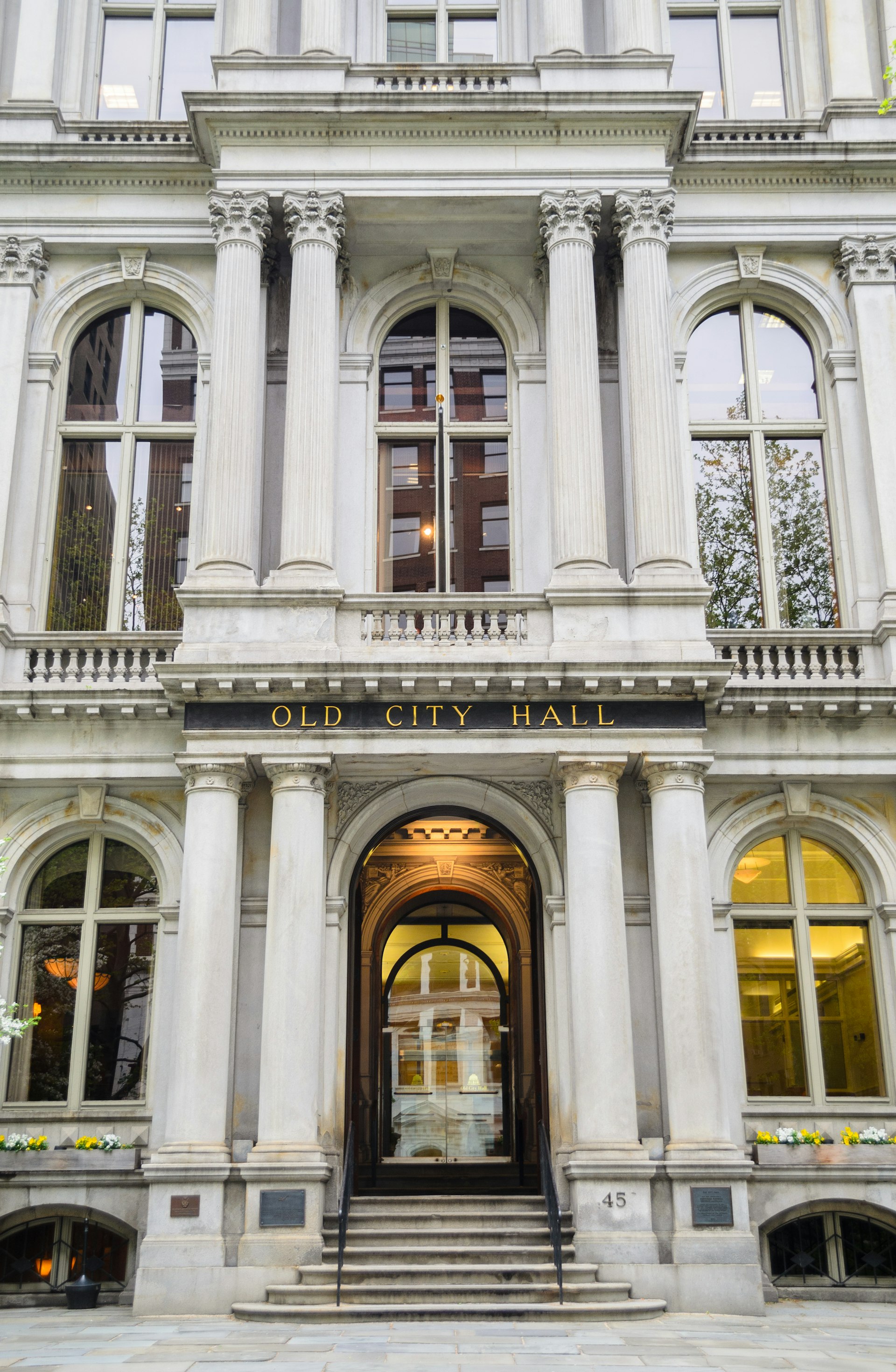 A building with grand columns and large windows and doors with the sign "Old City Hall" above the door