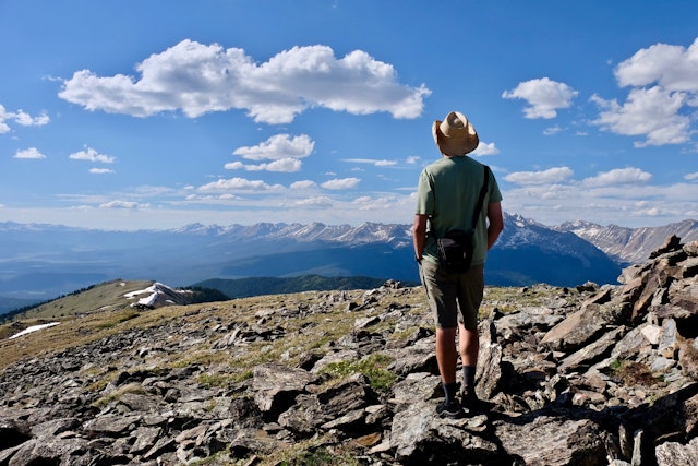 A man in a cowboy hat pausing to admire the views above Aspen, Colorado