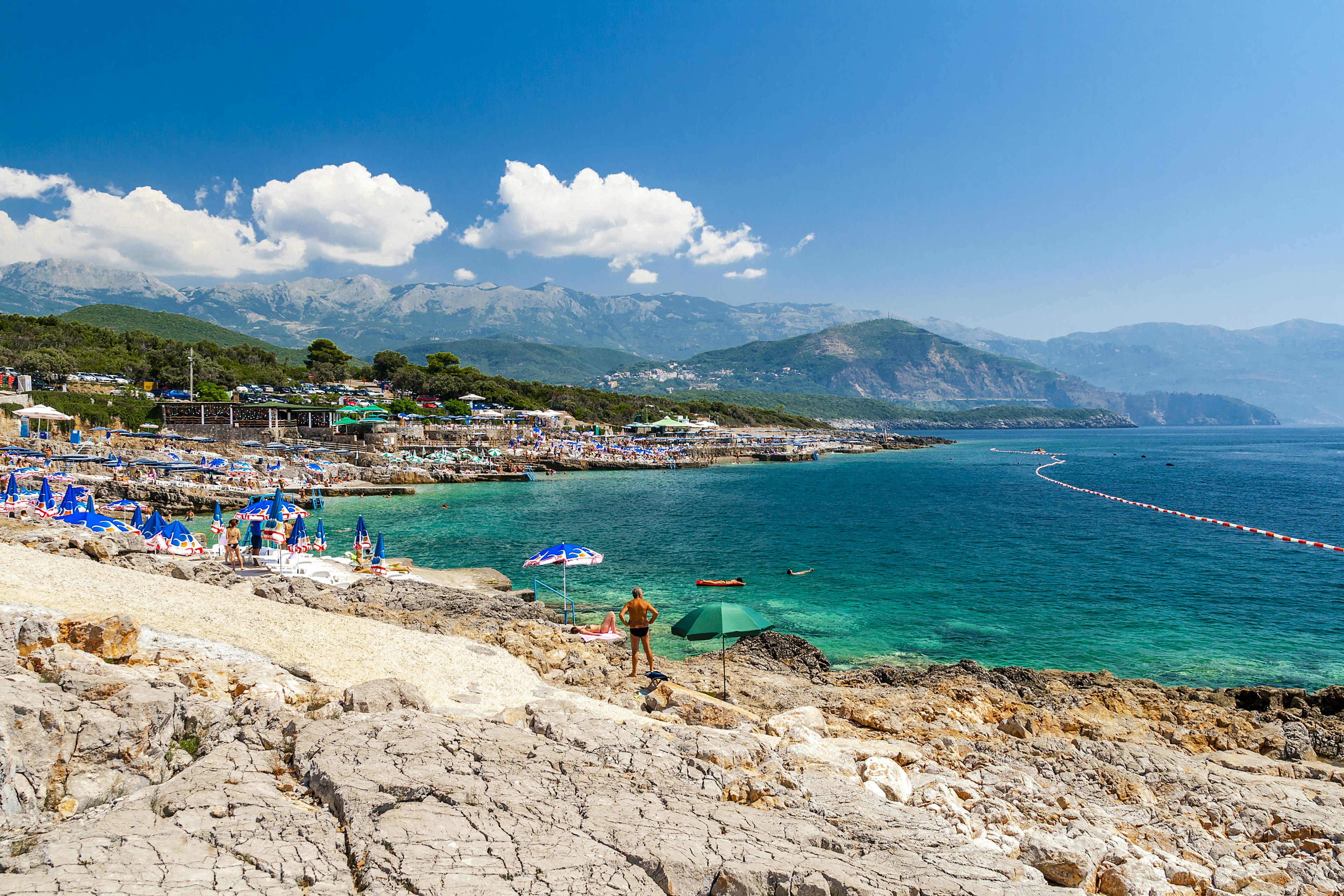 Umbrellas and bathers scattered around Ploce Beach.