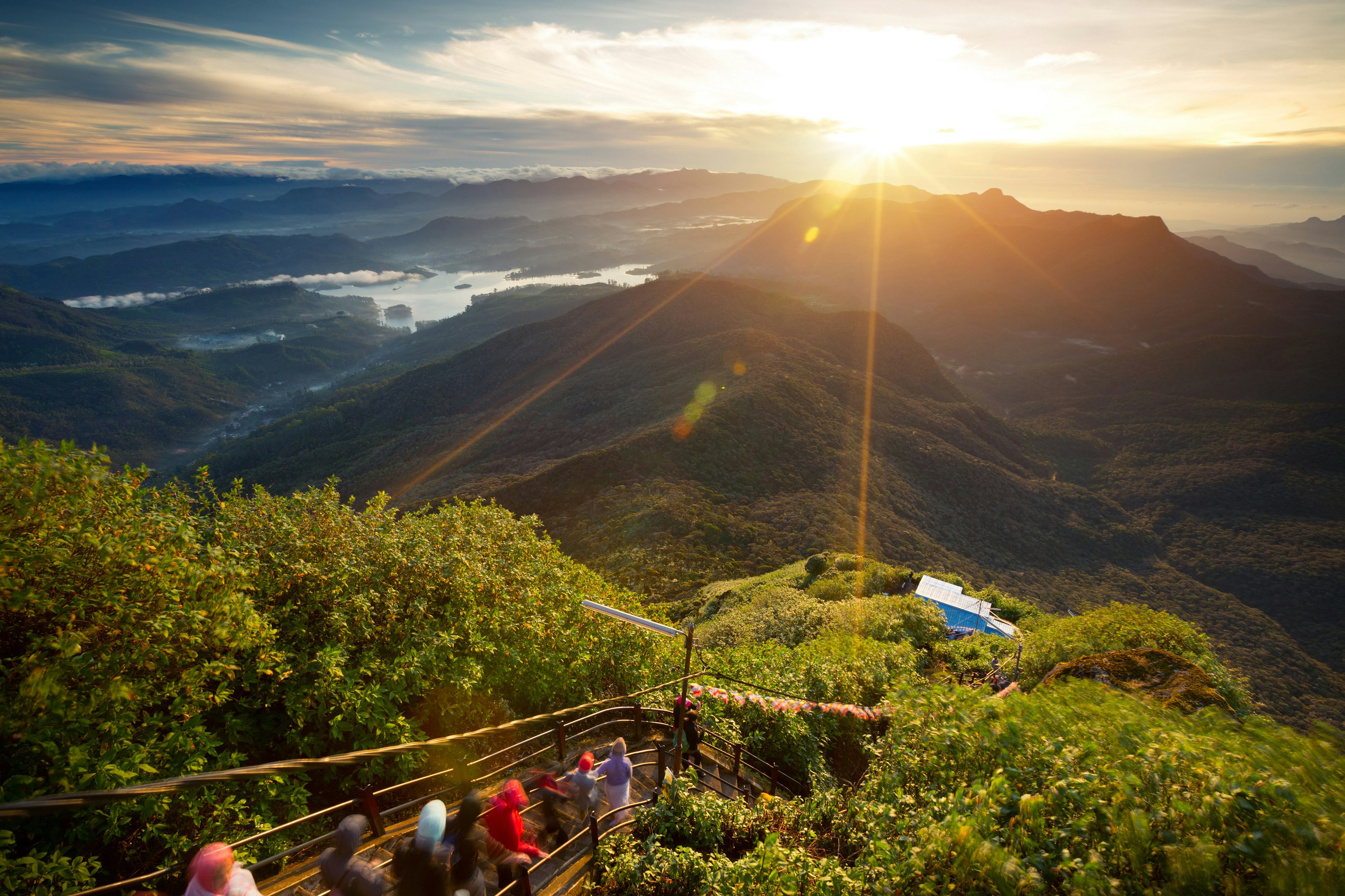 Hikes on the trail to the top of Adam's Peak (Sri Pada) in Sri Lanka at sunrise.