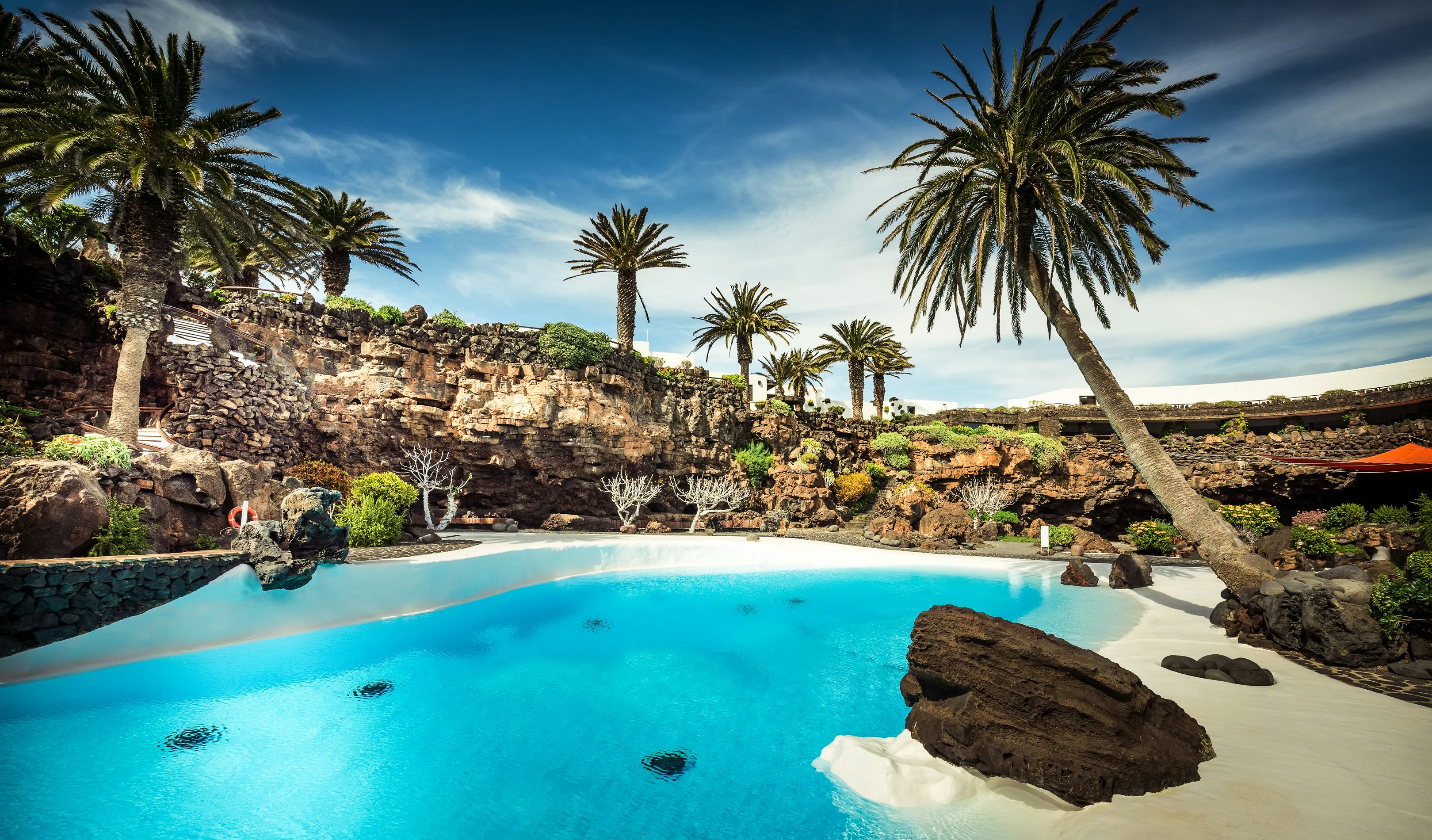 Jameos del Agua pool surrounded by rocks and palm trees in Lanzarote, Canary Islands, Spain