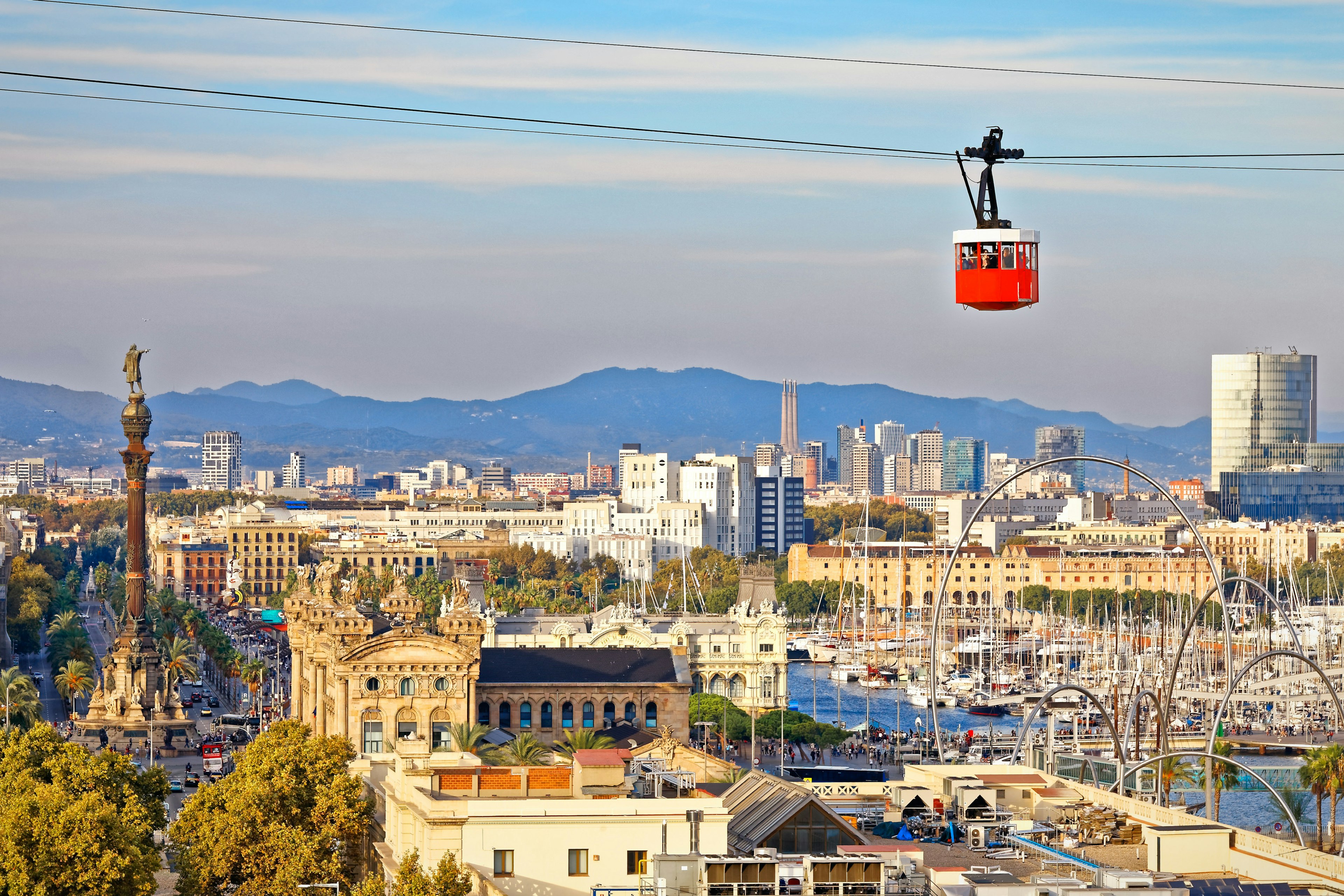 Red cabin of funicular (cable car) stands out on Barcelona's city backdrop