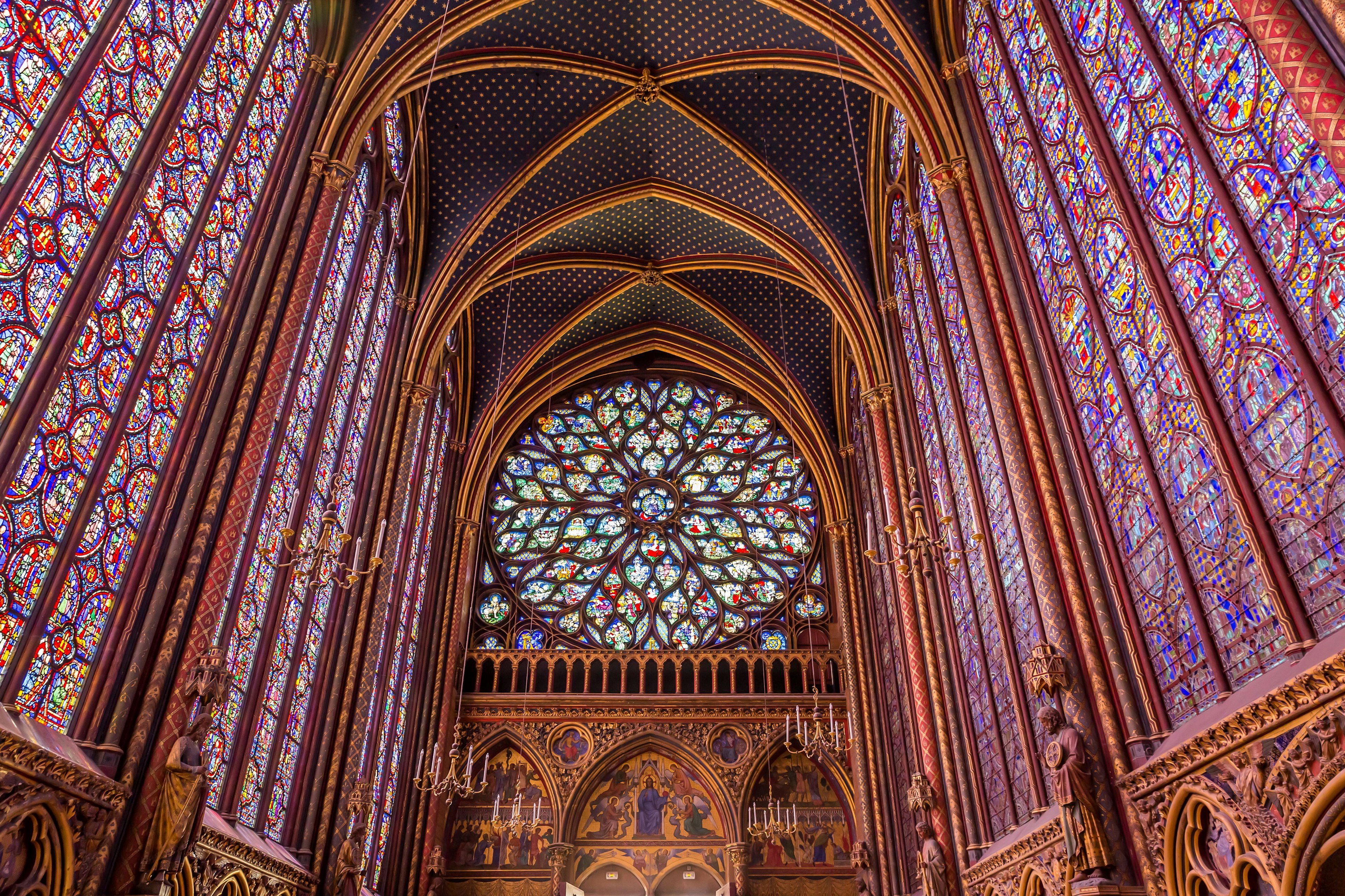 The colorful stained glass windows inside of a gothic French church.