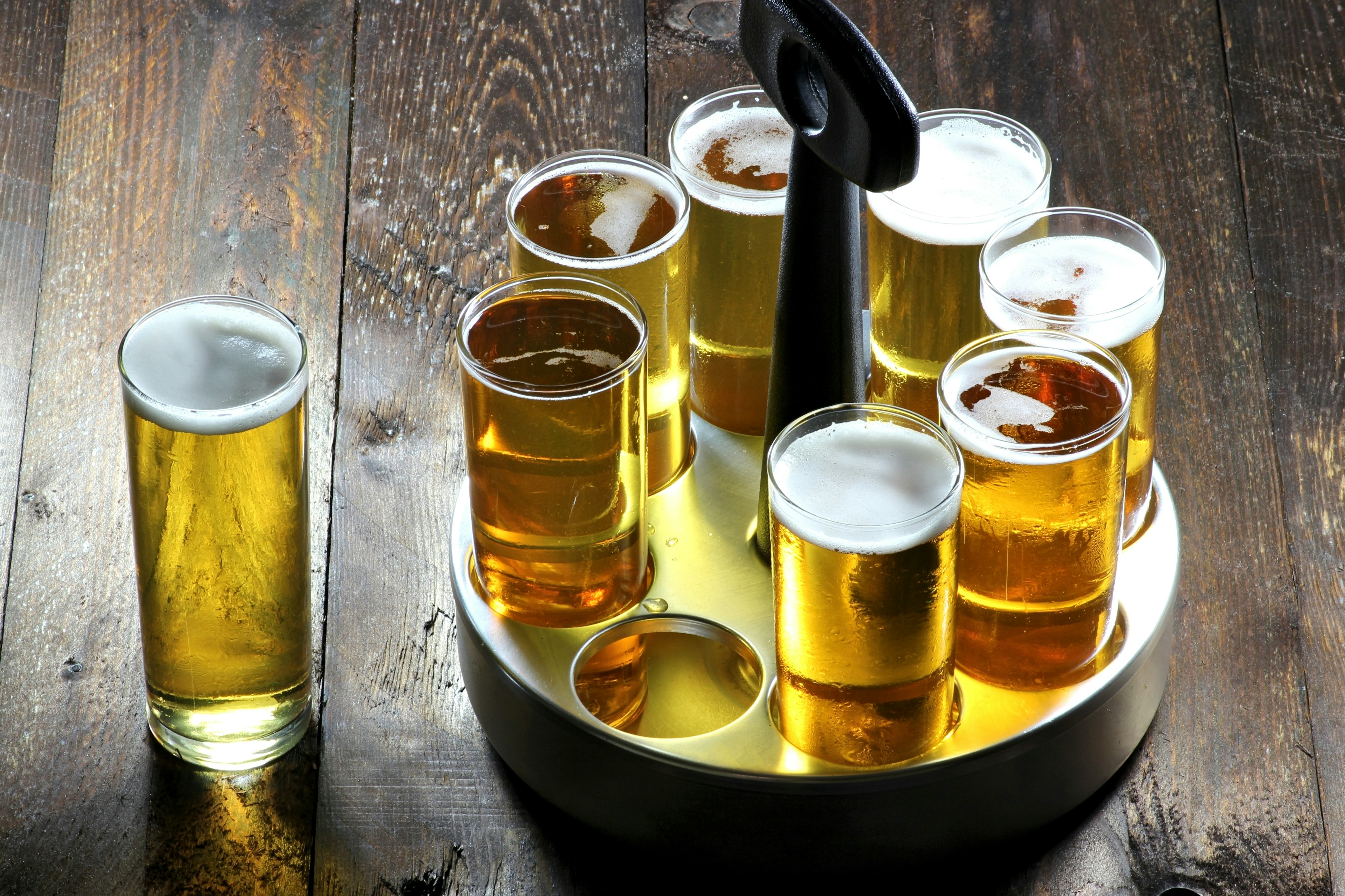 Tray of Kolsch (specialty beer from Cologne) beer served on a wooden table at a Cologne bar.