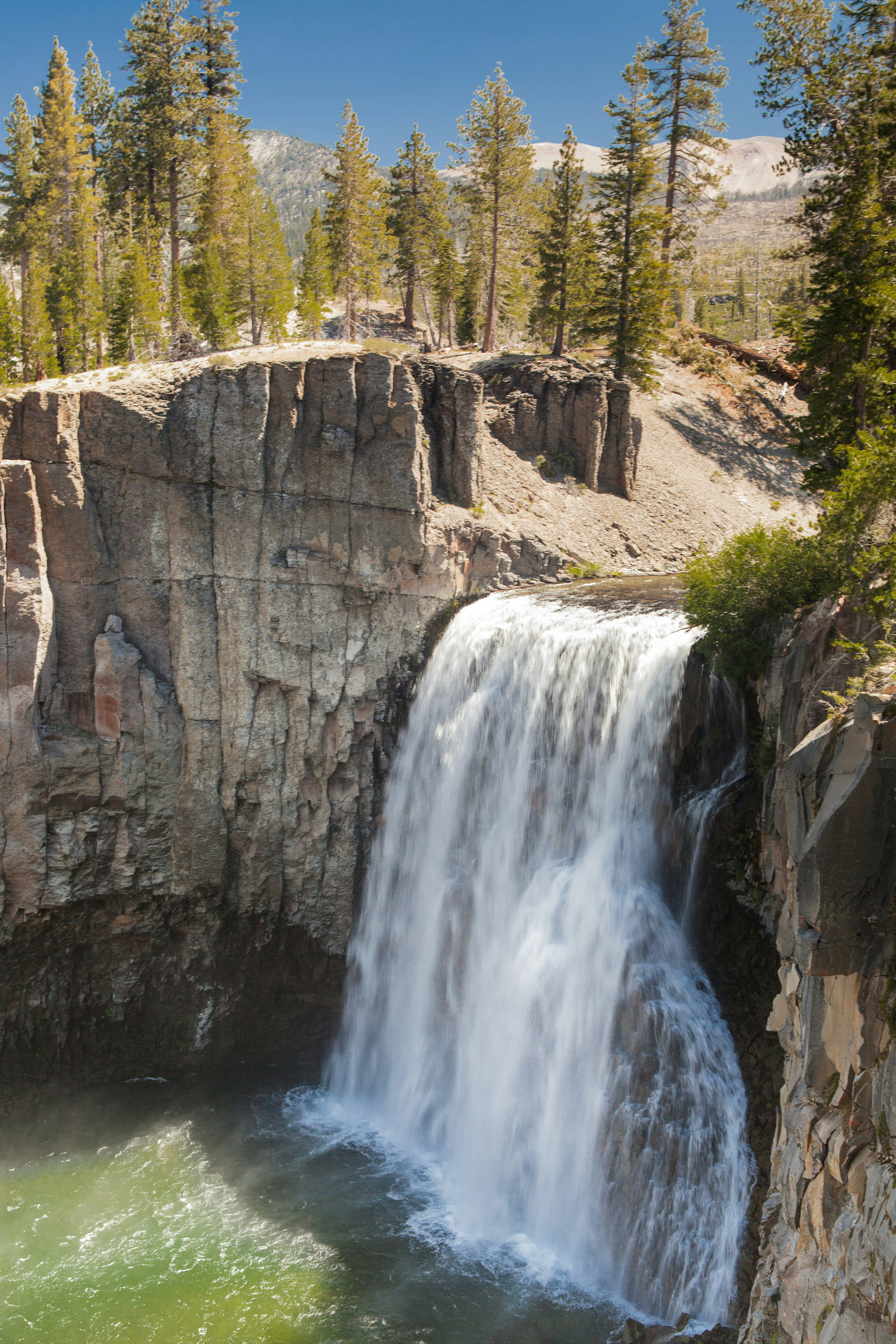 A waterfall gushes down a rocky cliff