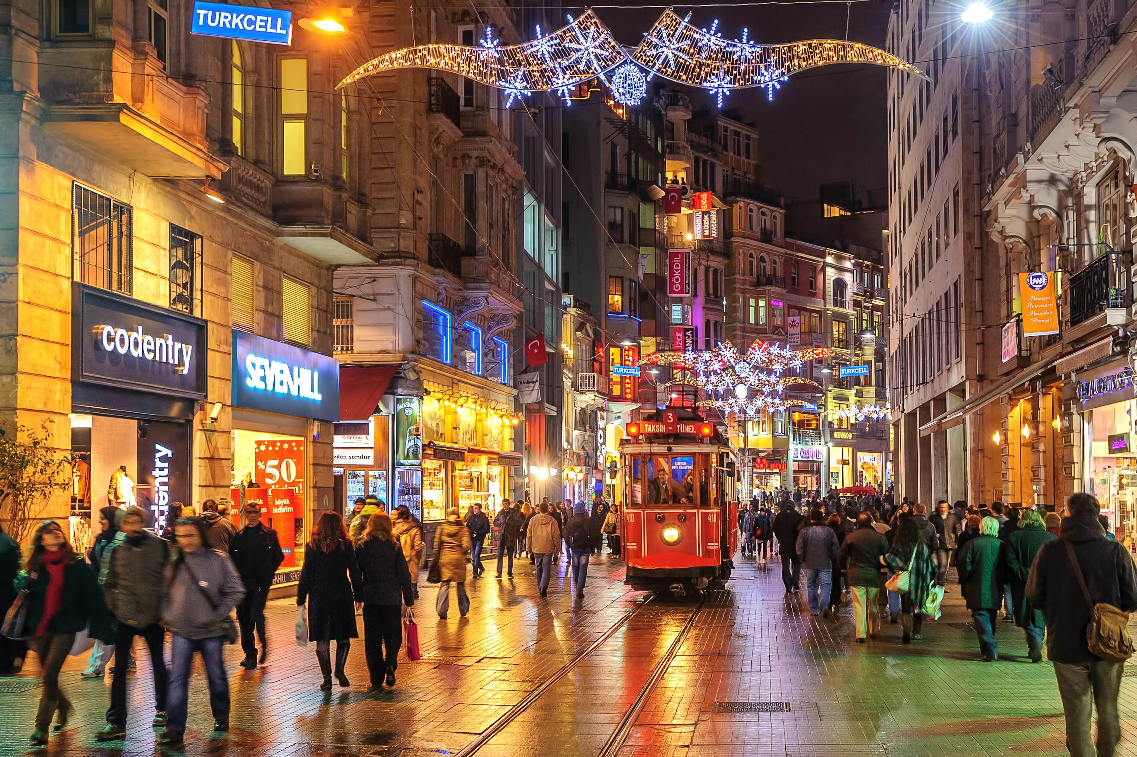 People walking on Istiklal Street in Beyoğlu, Istanbul with a tram running up the center