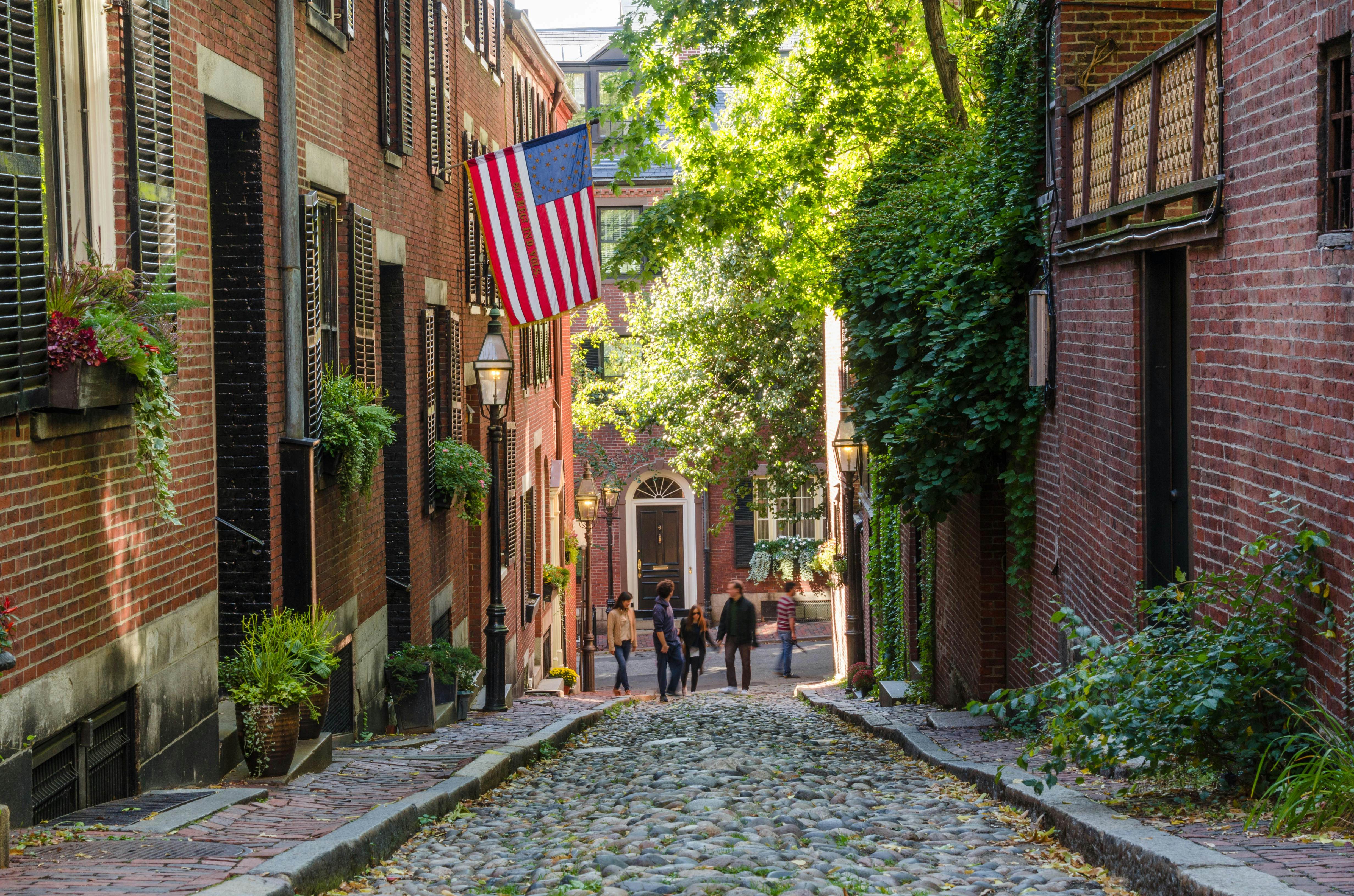 Tourists wandering along Acorn Street in Beacon Hill on a warm autumn day