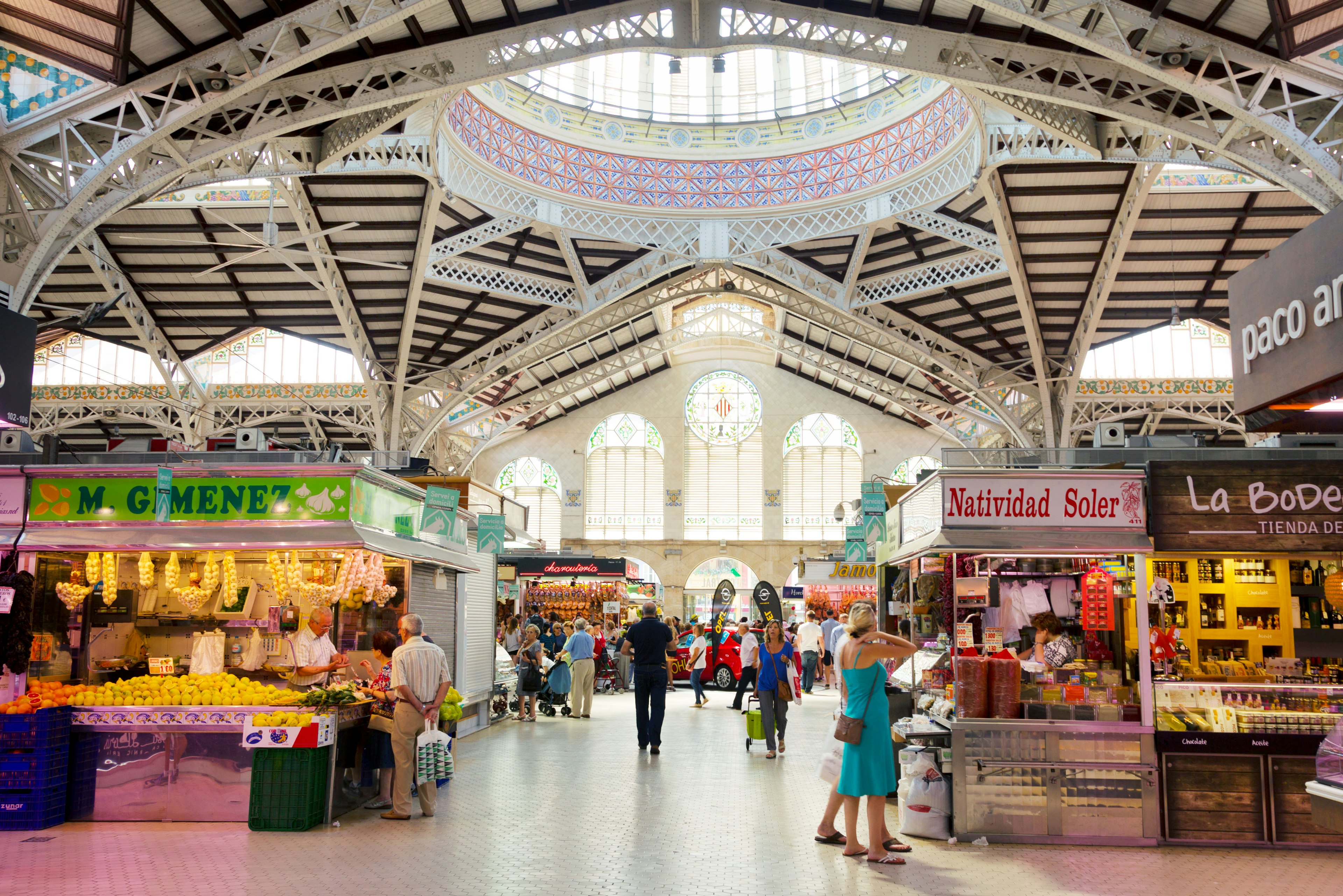 An interior shot of people shopping in Valencia's Mercado Central, one of the oldest in Europe and a combination of architectural styles, including late gothic and modernism.