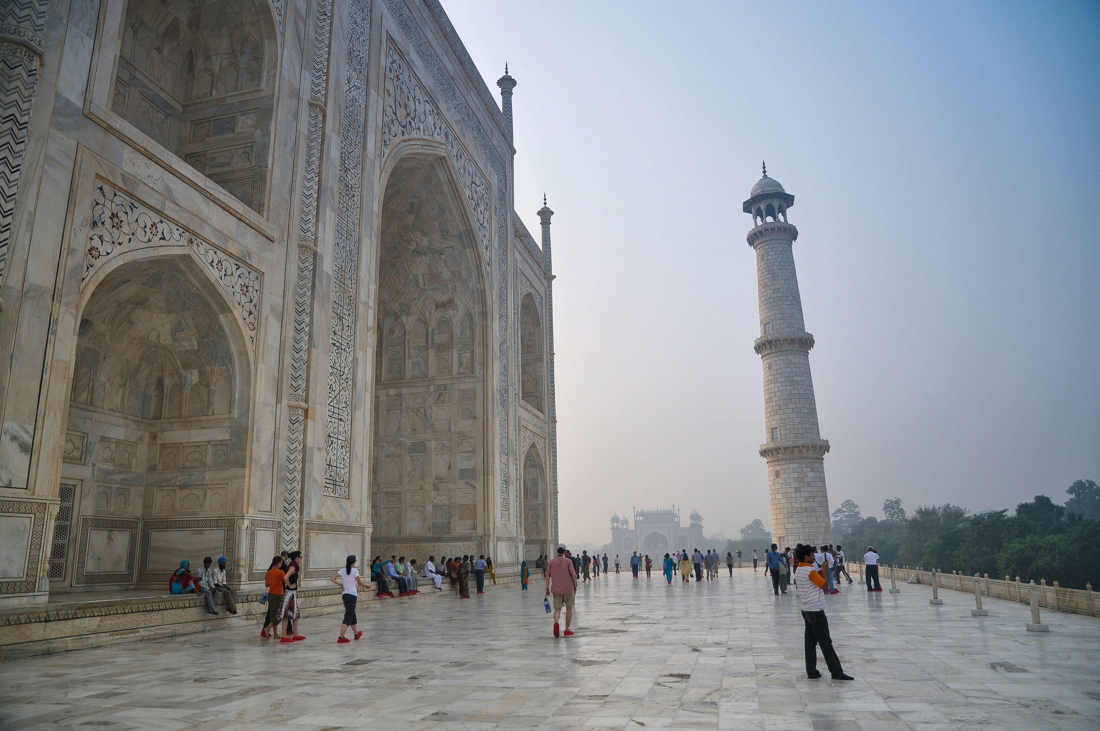 Visitors gather on the terrace at the Taj Mahal, Agra, India, in misty light.