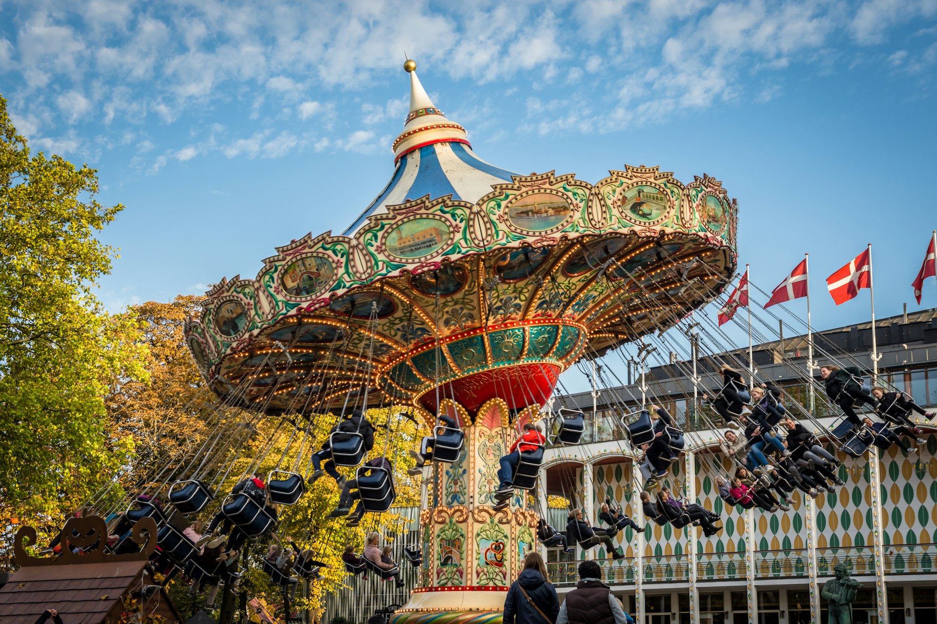 Families enjoying the old-fashioned swing ride at Tivoli Gardens, Copenhagen.