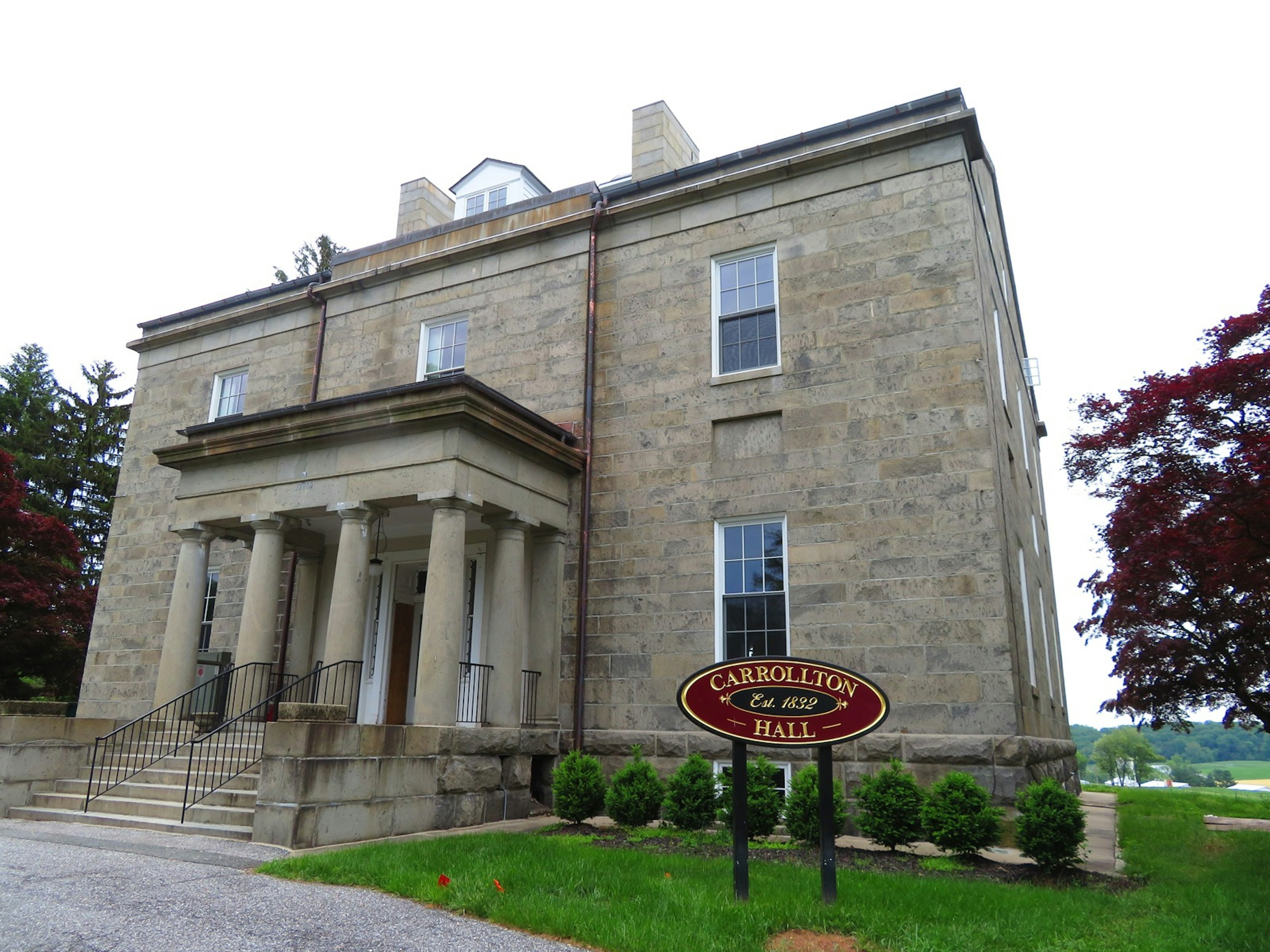 A stone building with a sign reading