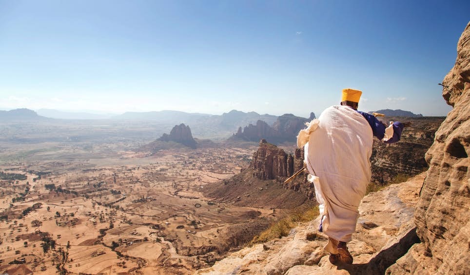 A priest on the precarious route up a mountain to one of Ethiopia’s cave churches © Philip Lee Harvey / Lonely Planet