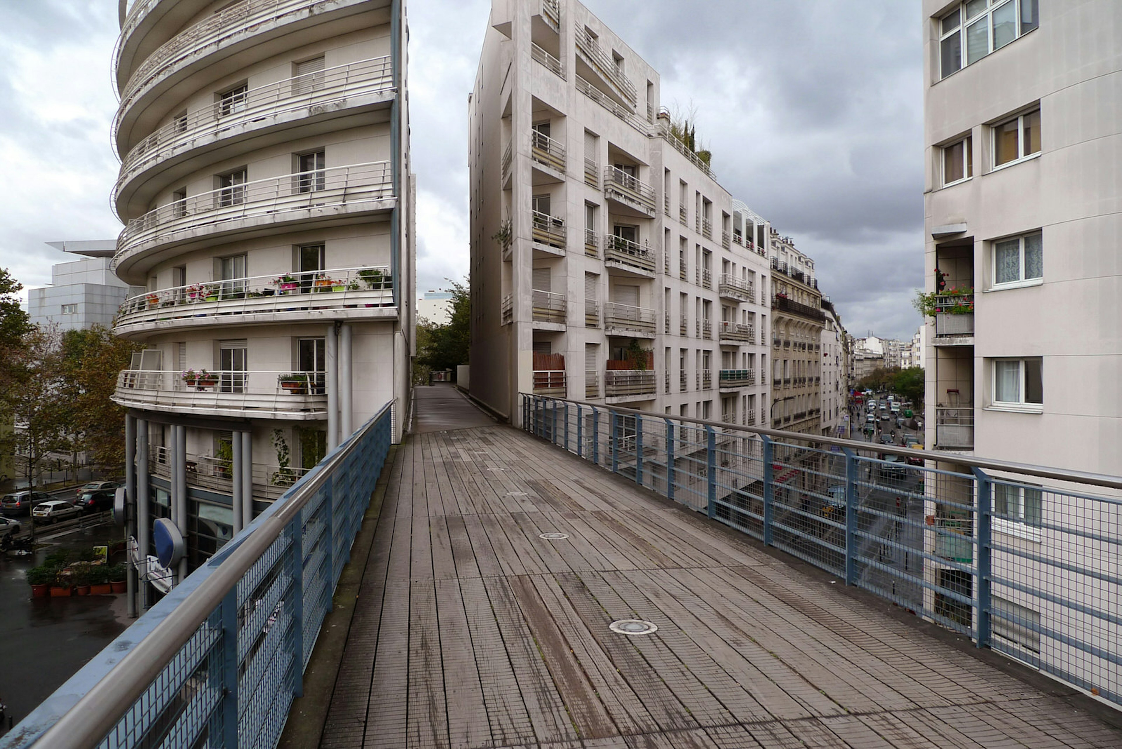 View of Promenade Plantée, a raised, narrow wooden-floored walkway between two buildings in Paris, France