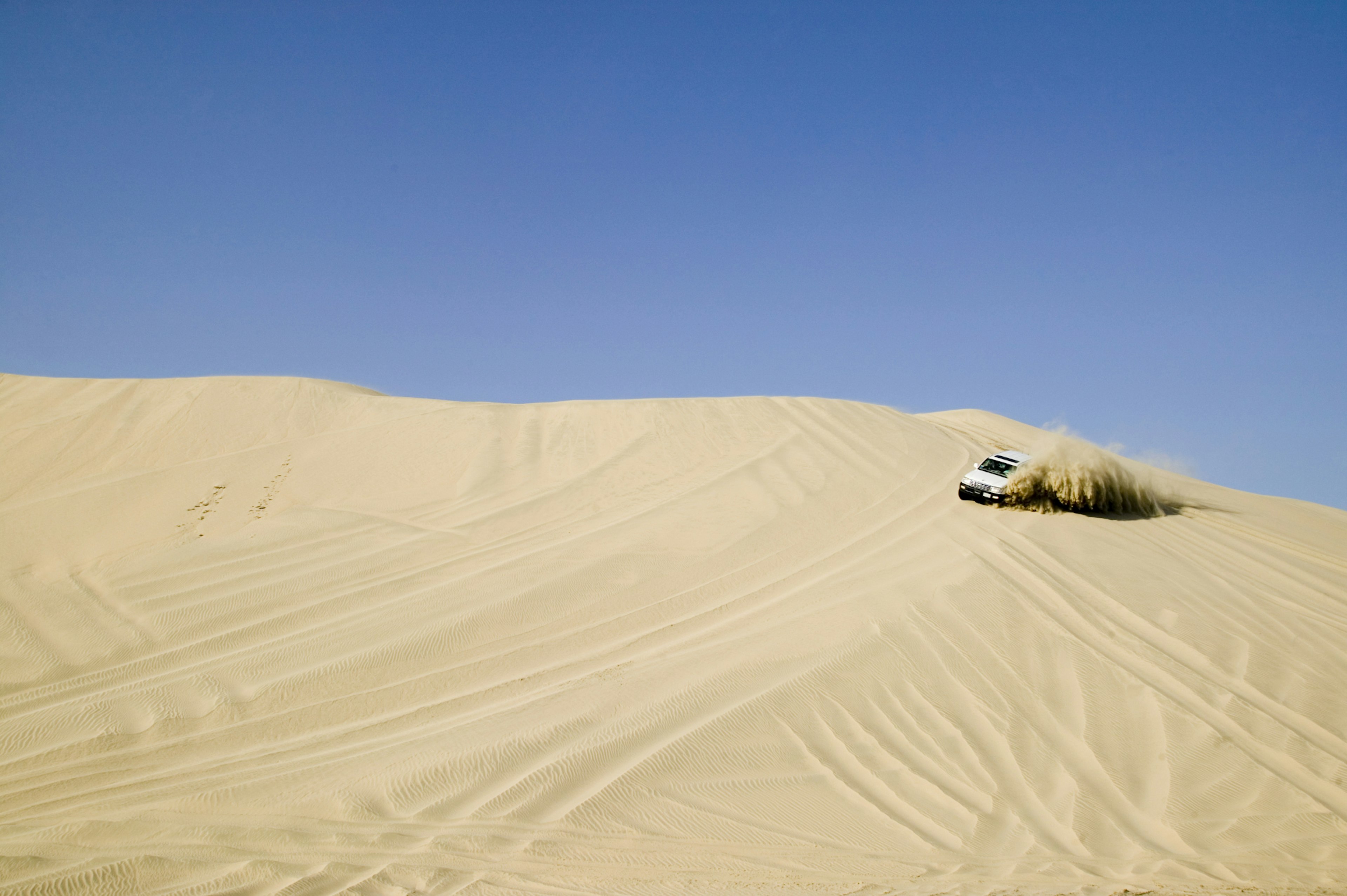 Driving the desert dunes. Image by Matilde Gattoni / ArabianEye / Getty Images