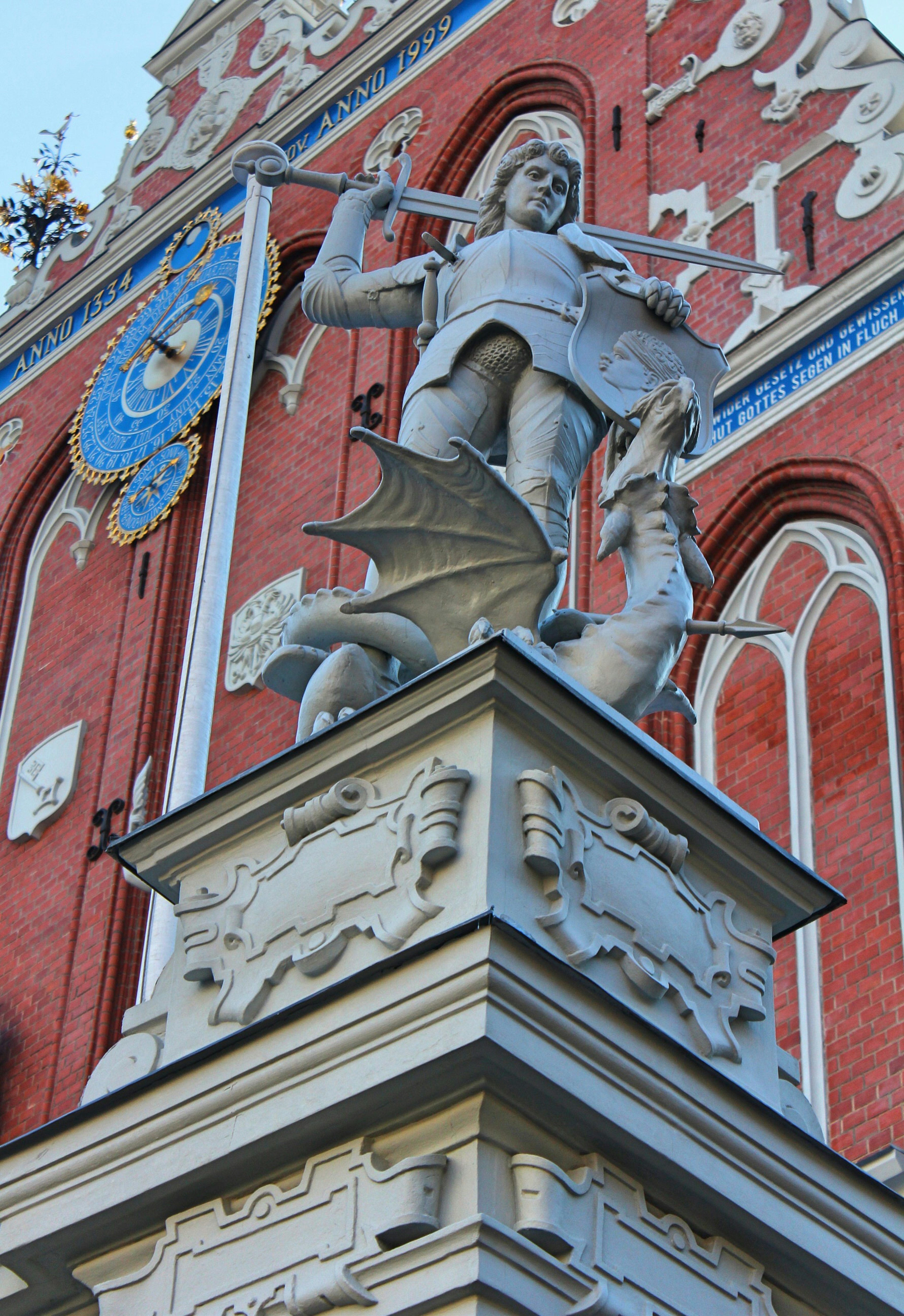 Portrait shot of a statue in Riga's Old Town, with the red-bricked House of the Blackheads behind © Caroline Hadamitzky / ϰϲʿ¼