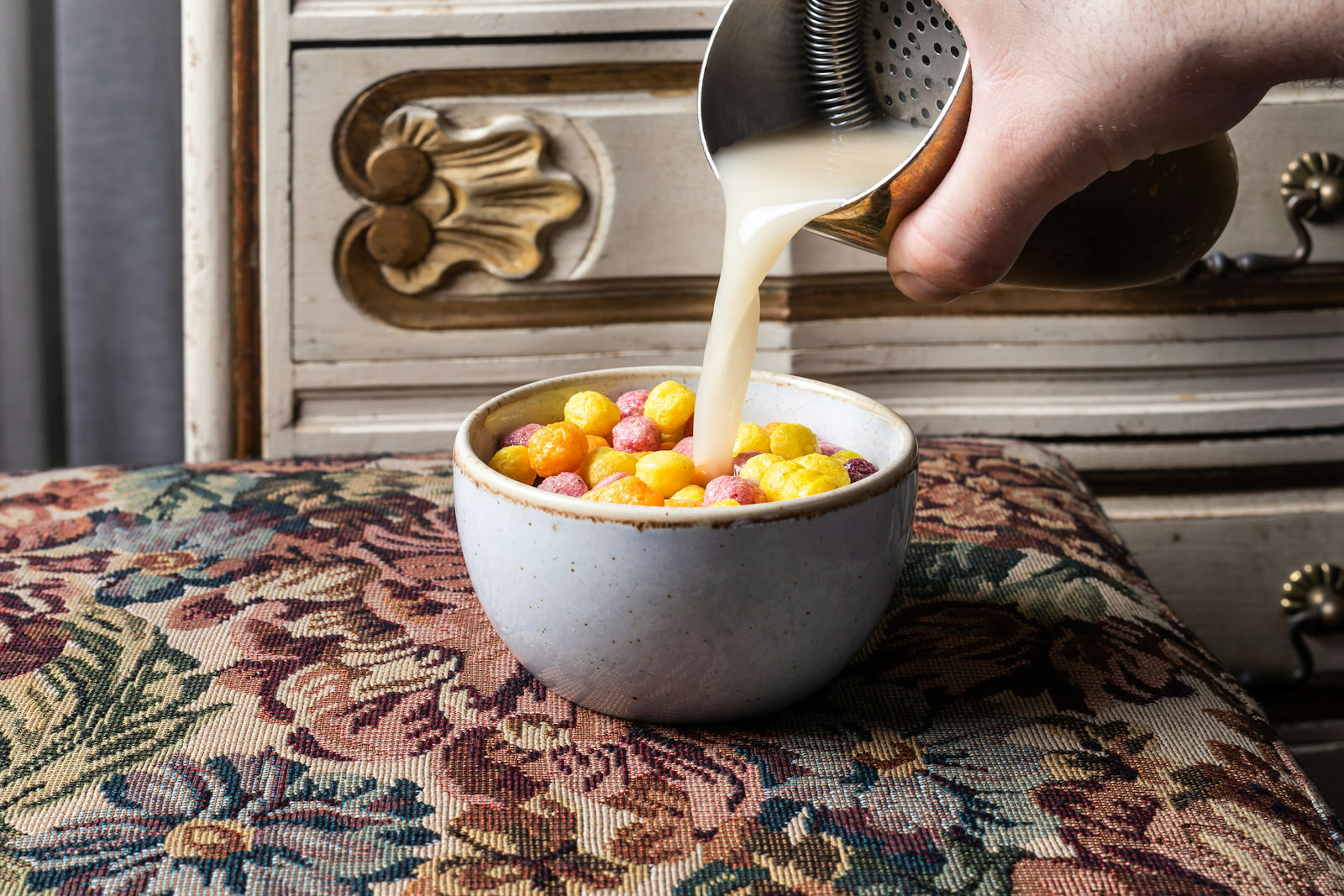 Cocktail being poured into what looks like a bowl of cereal on a needlepoint tablecloth at 223, Tel Aviv © 223