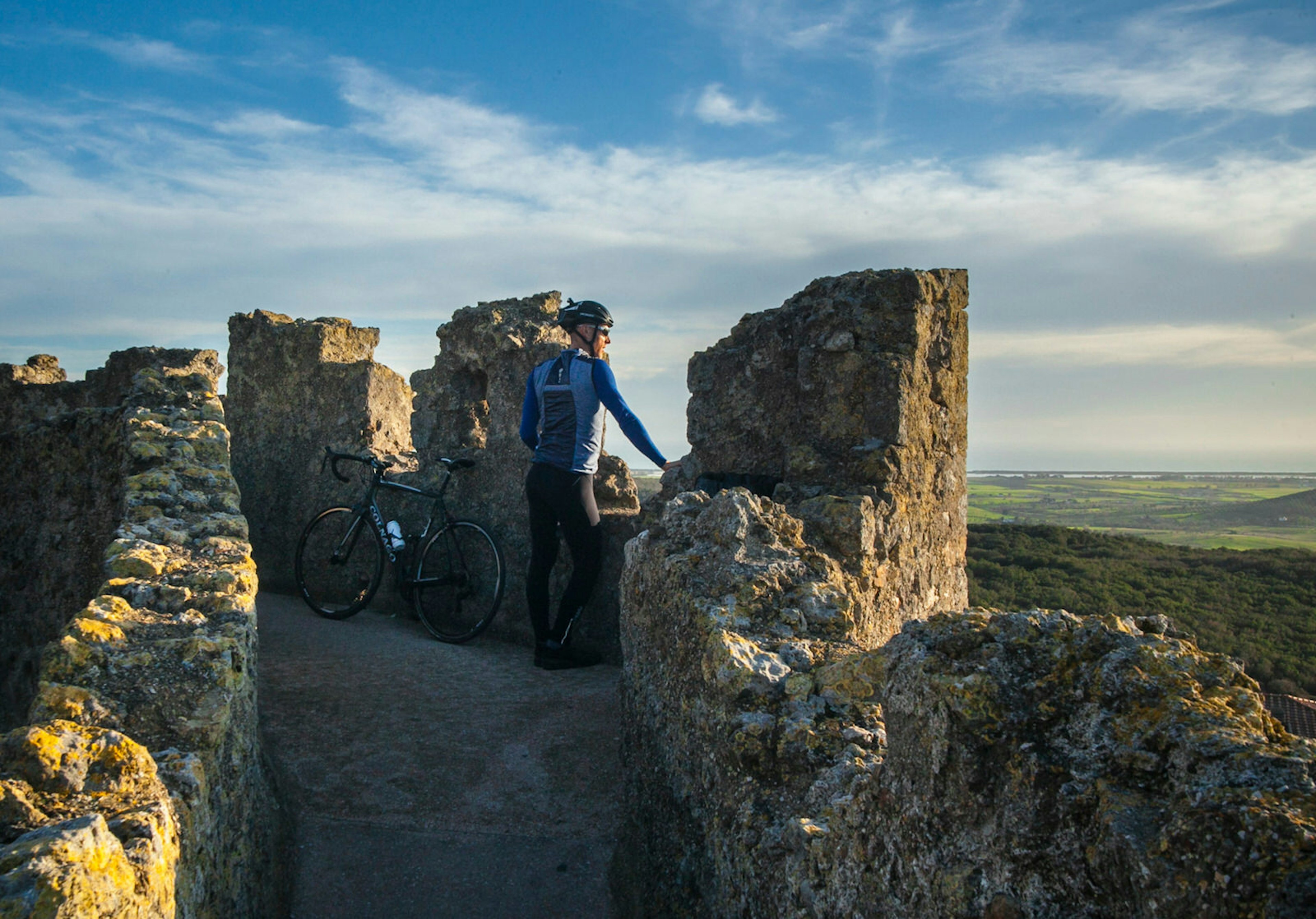 With his bike leaning against the crenulated ramparts, writer Matt Phillips looks out over the green rolling landscape to the Costa d'Argento © Ciclica & Foto Mariollorca.com