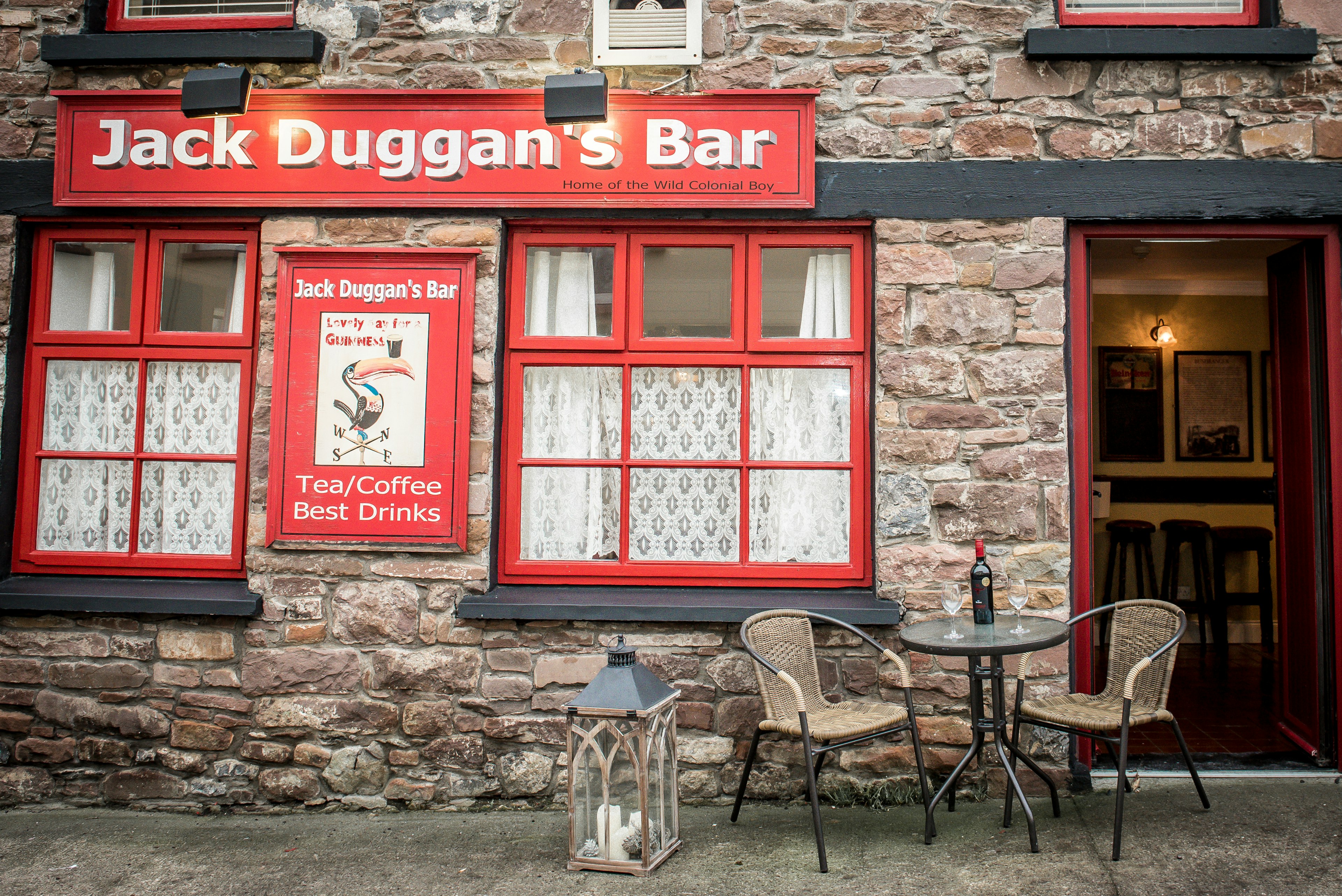 The exterior of a red pub in the Irish countryside.