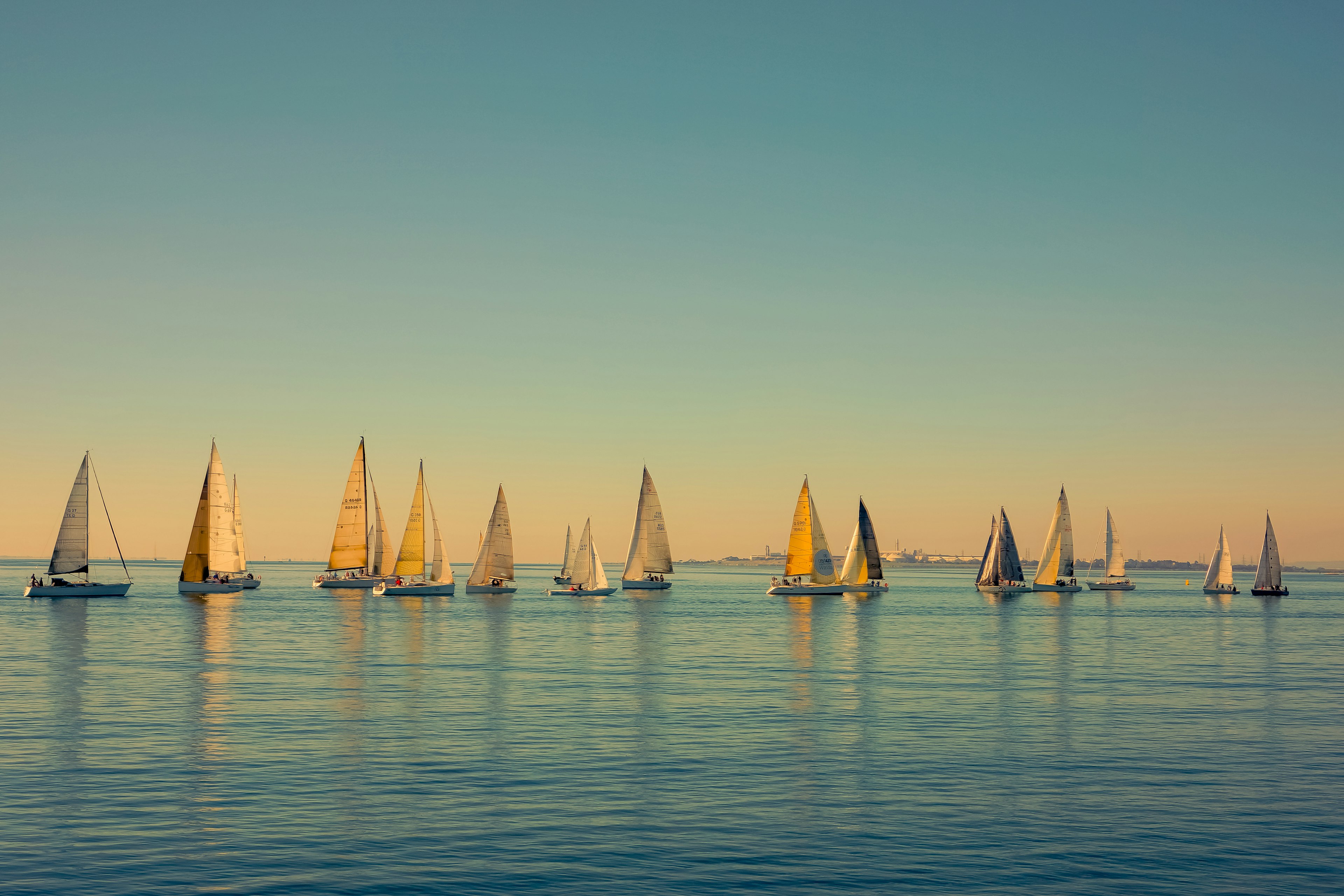 Sailing boats bobbing in Corio Bay at sunset by Geelong Pier