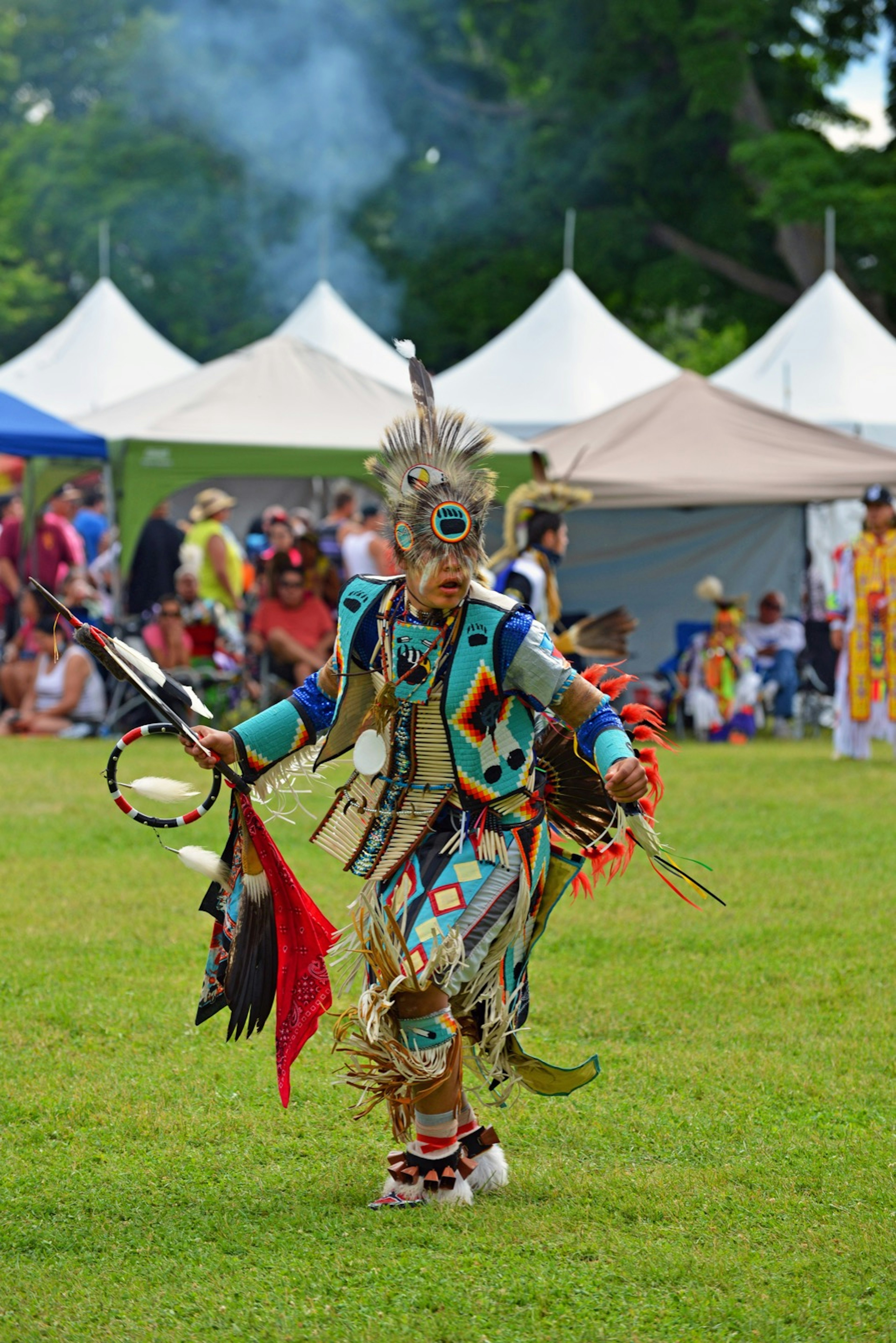 A teenage boy dressed in traditional clothing with colorful beads and feathers dances during the Summer Solstice Indigenous Arts Festival in Ottawa.