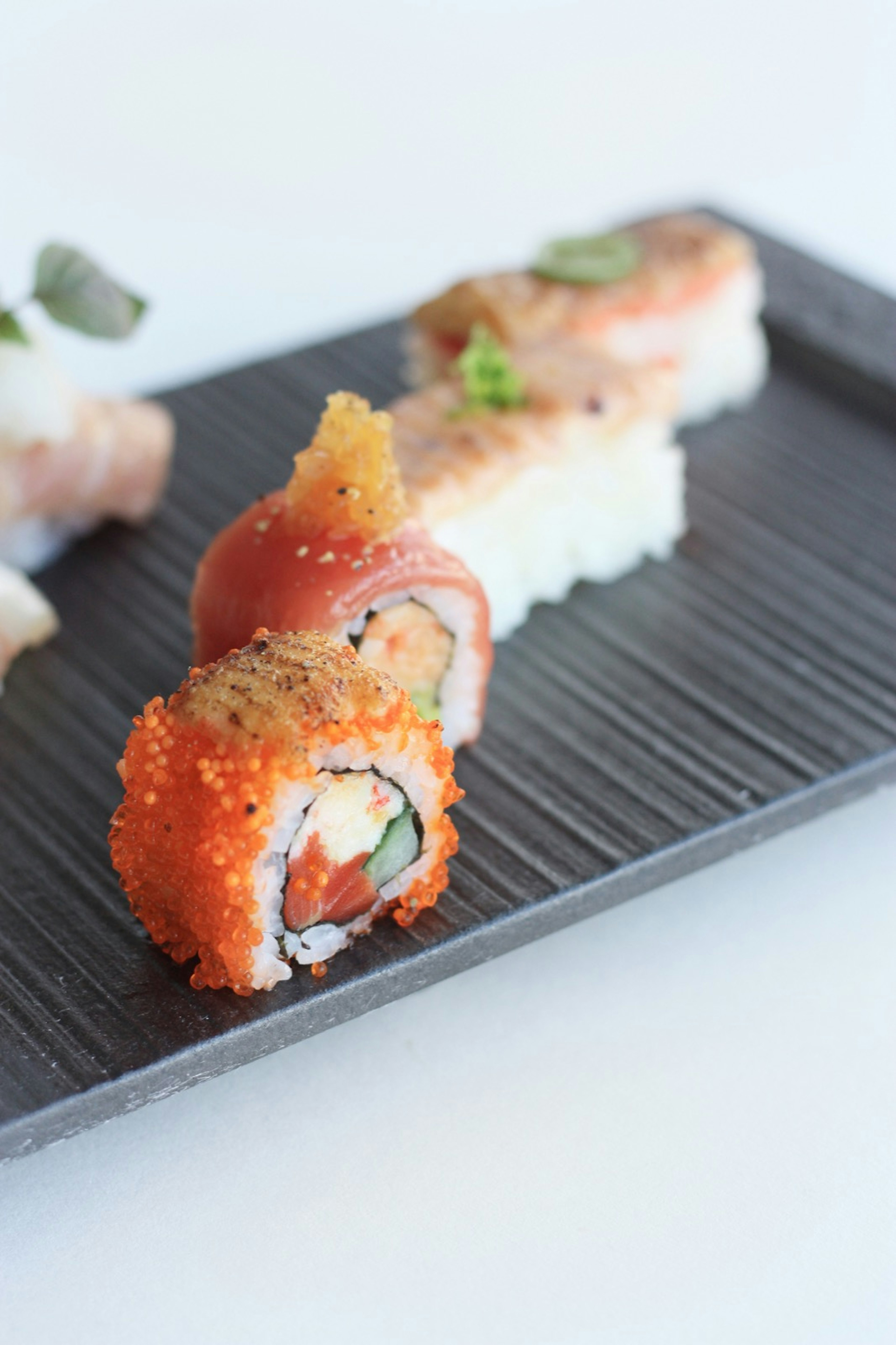 Four pieces of sushi arranged on a plate; California roll