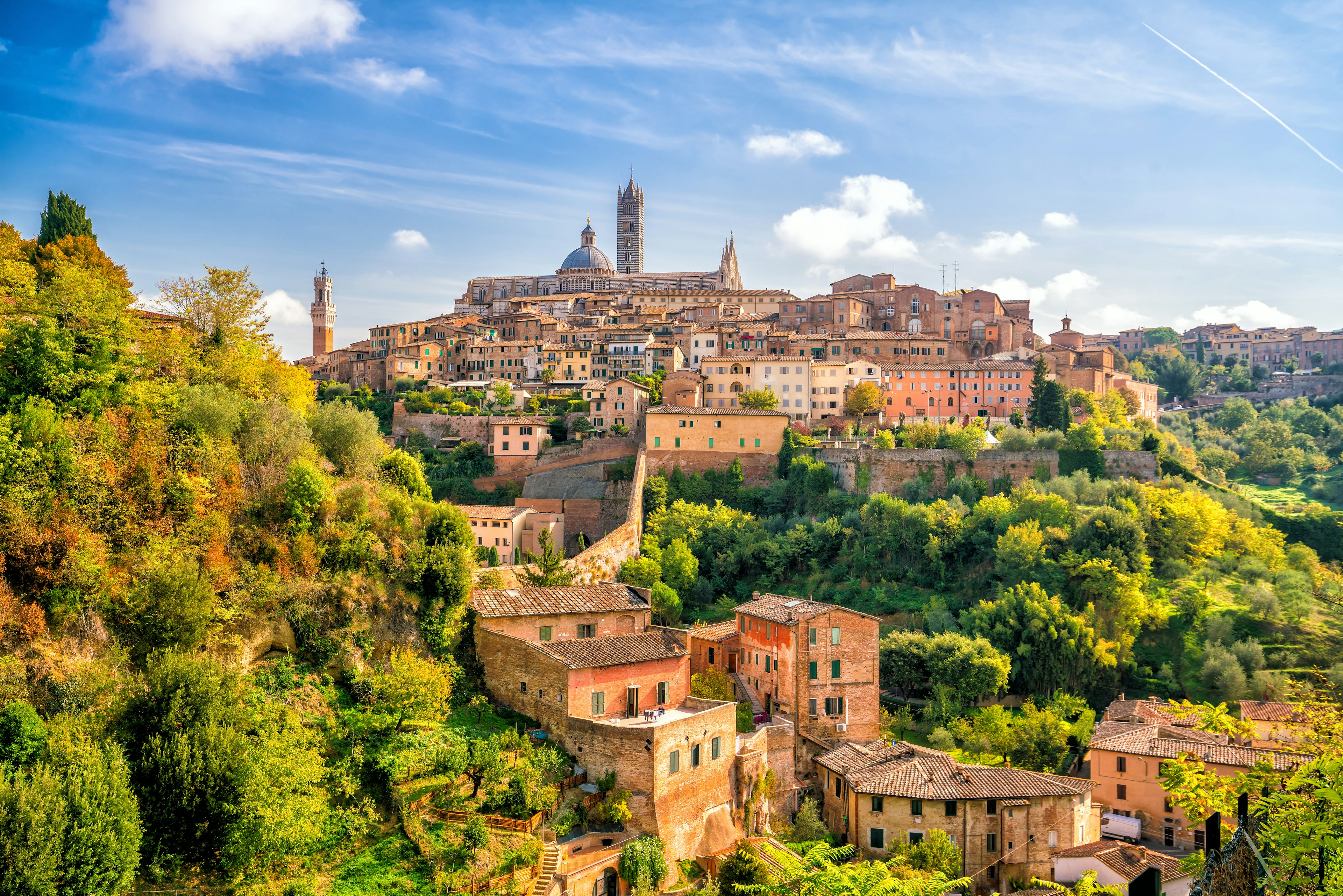 The historic hilltop town of Siena glows in the early autumn sun. Adobe Stock