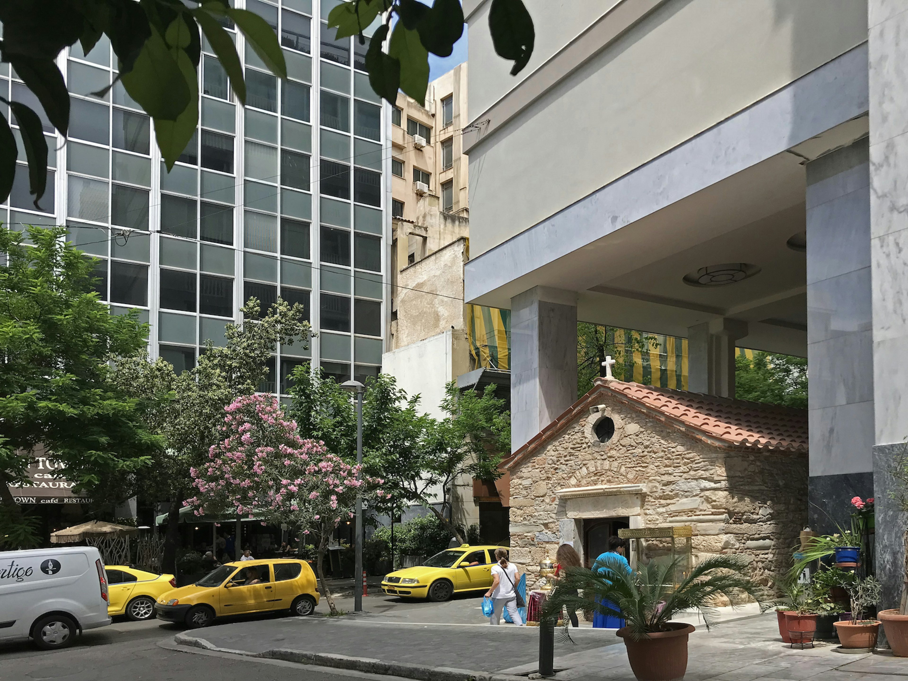 The entrance to Agia Dynami, a small cross on top and on the corner of a street with taxi cabs