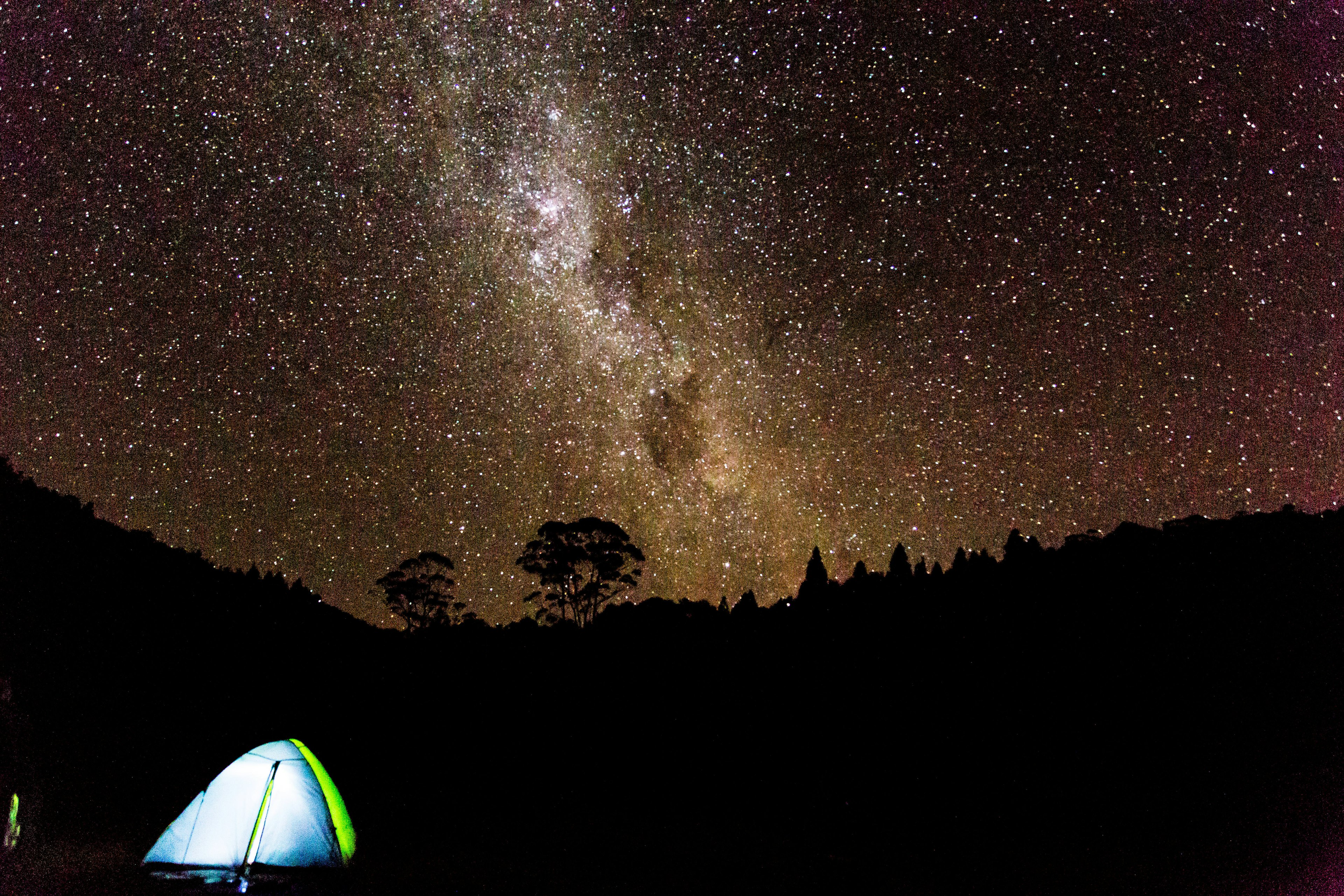 A tent under a brilliant night sky full of stars in New Zealand