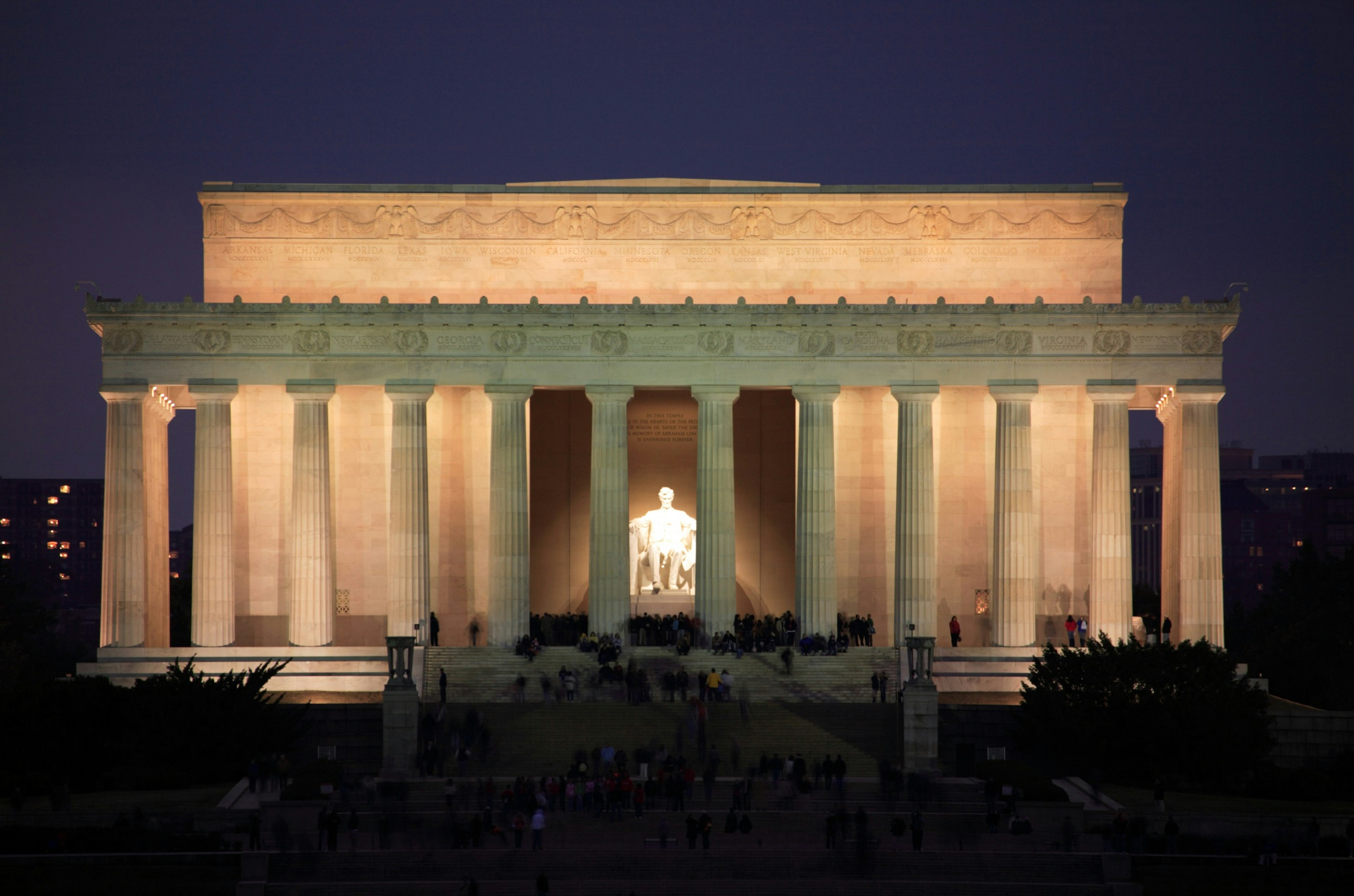 The statue of Abraham Lincoln is illuminated inside the Lincoln Memorial temple at night