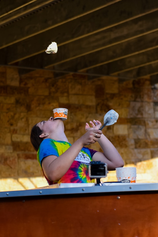 Woman flips ice cream into the air while balancing a cup on her chin © Amy's Ice Cream