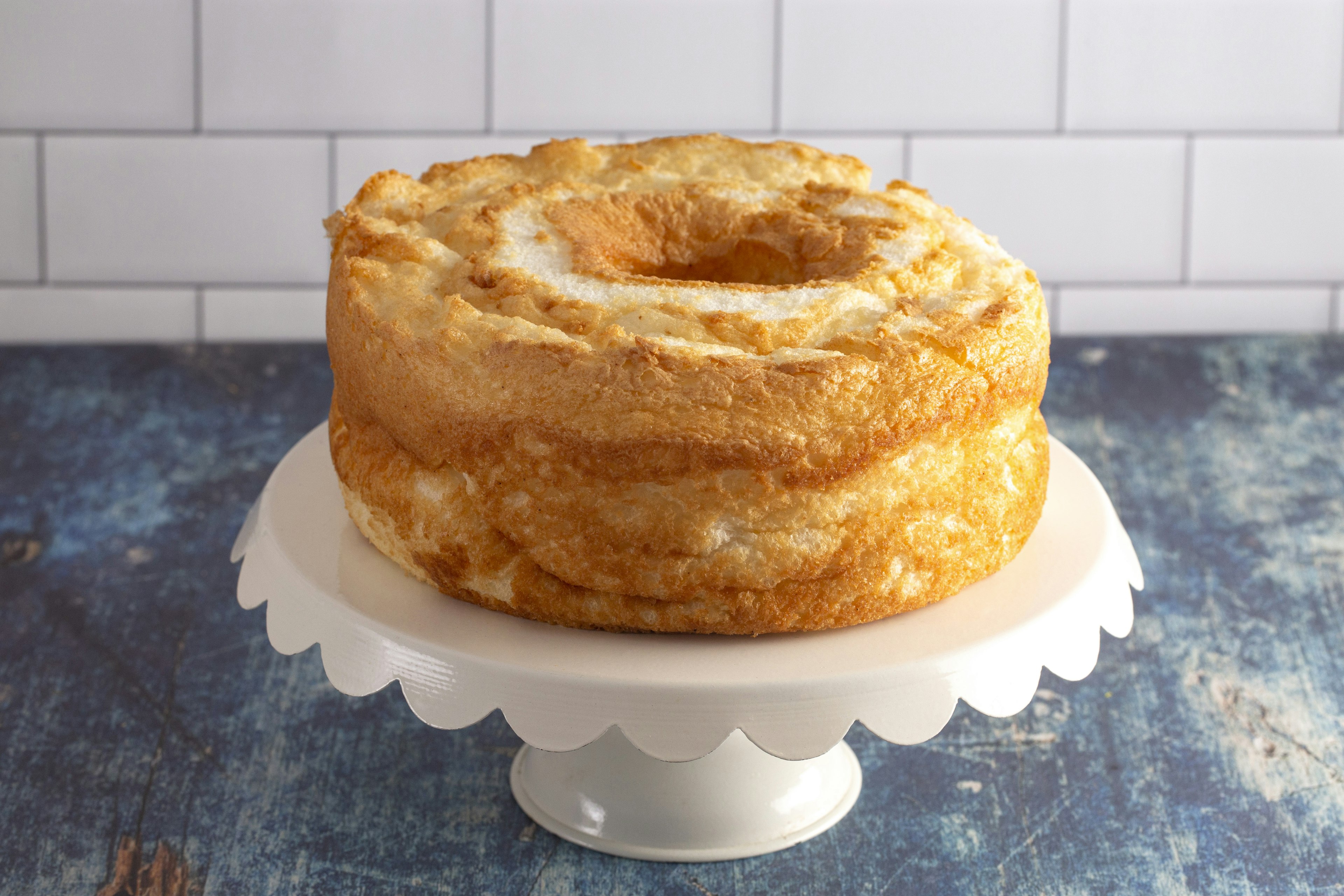 An Angel Food cake sits on a white cake stand