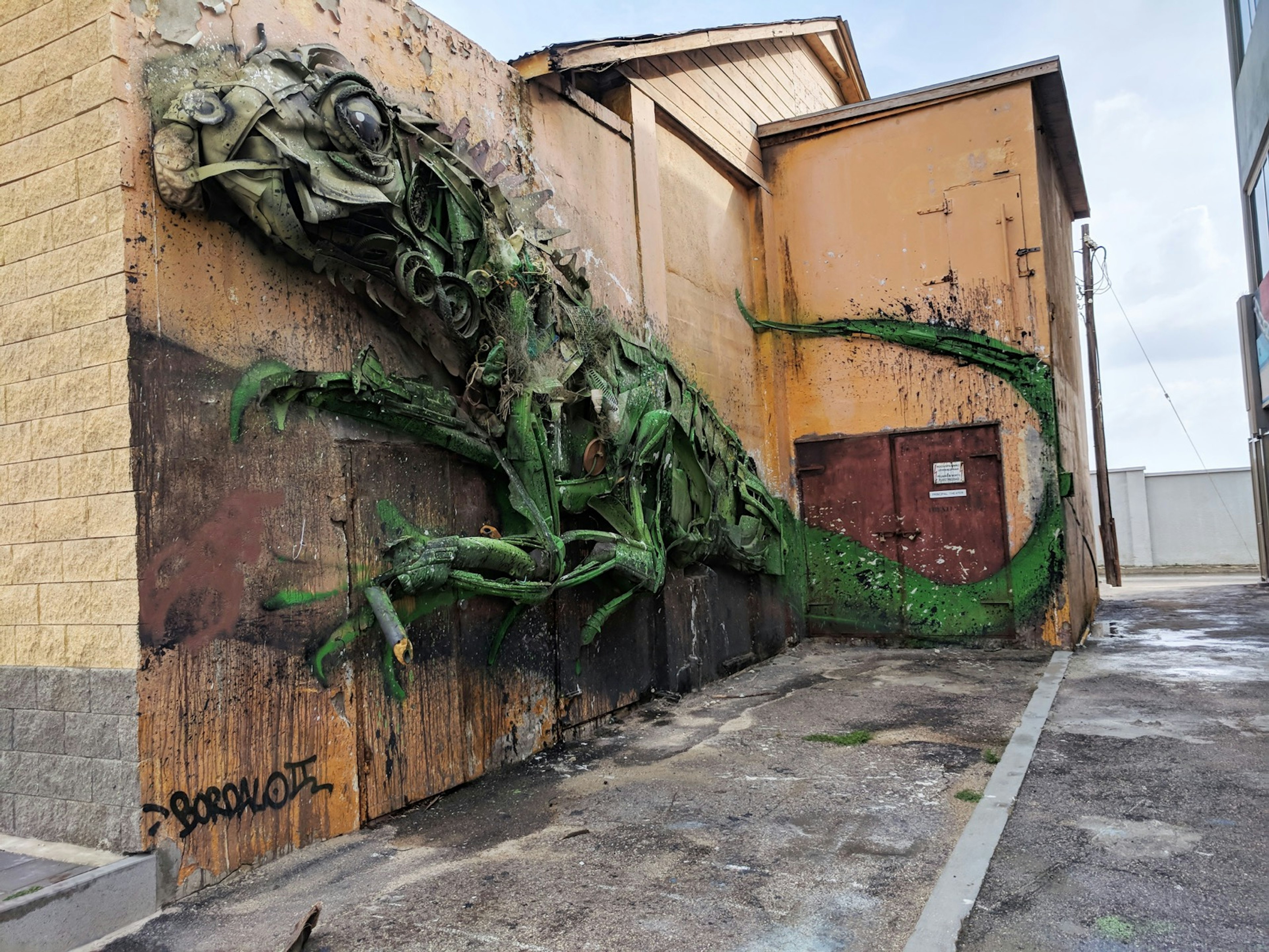 A large art installation of an iguana is positioned on the side of a building in the neighborhood of San Nicolas in Aruba © Alicia Johnson/Lonely Planet