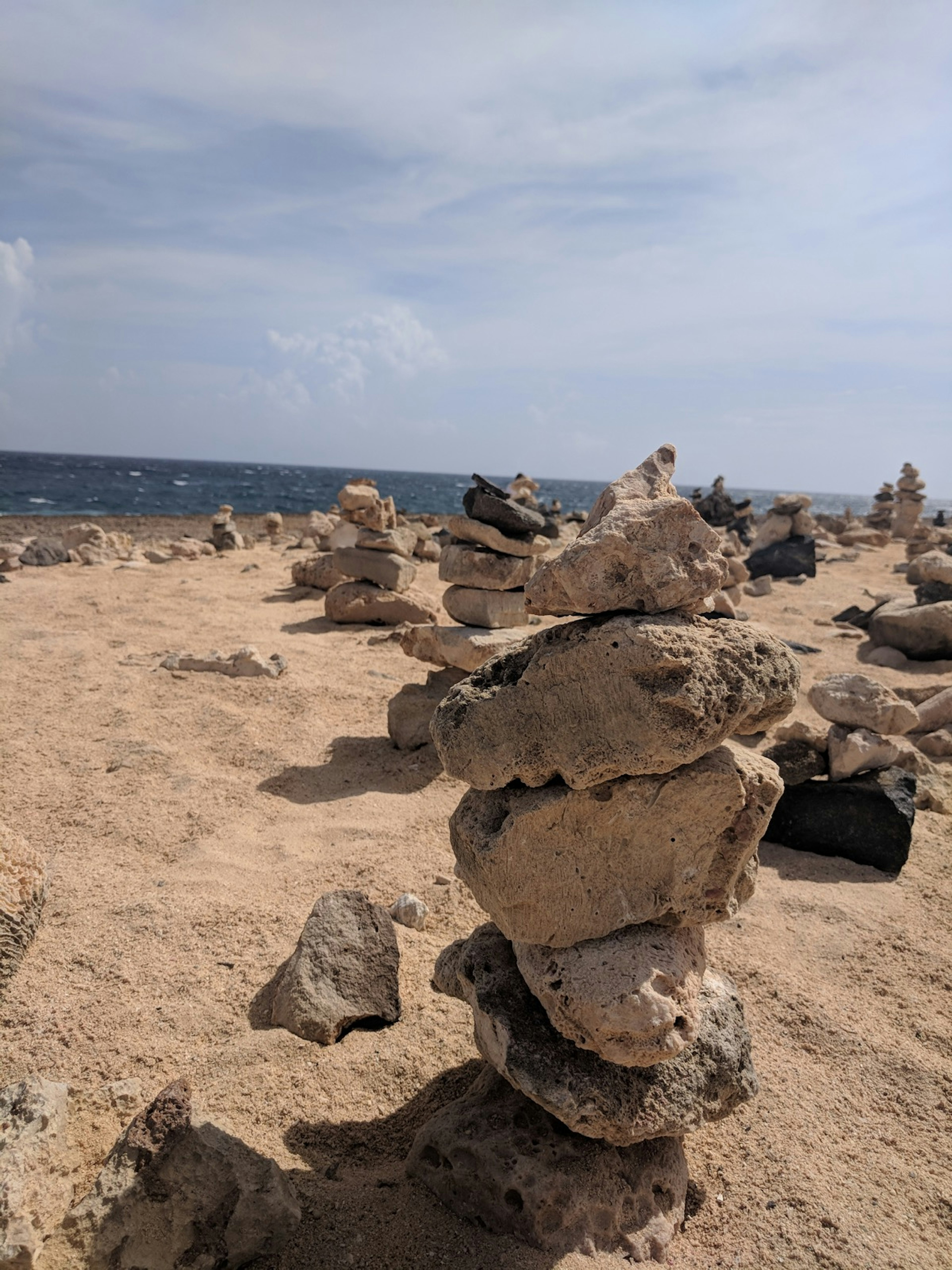 Stacks of rocks cover a beach in Aruba © Alicia Johnson/Lonely Planet