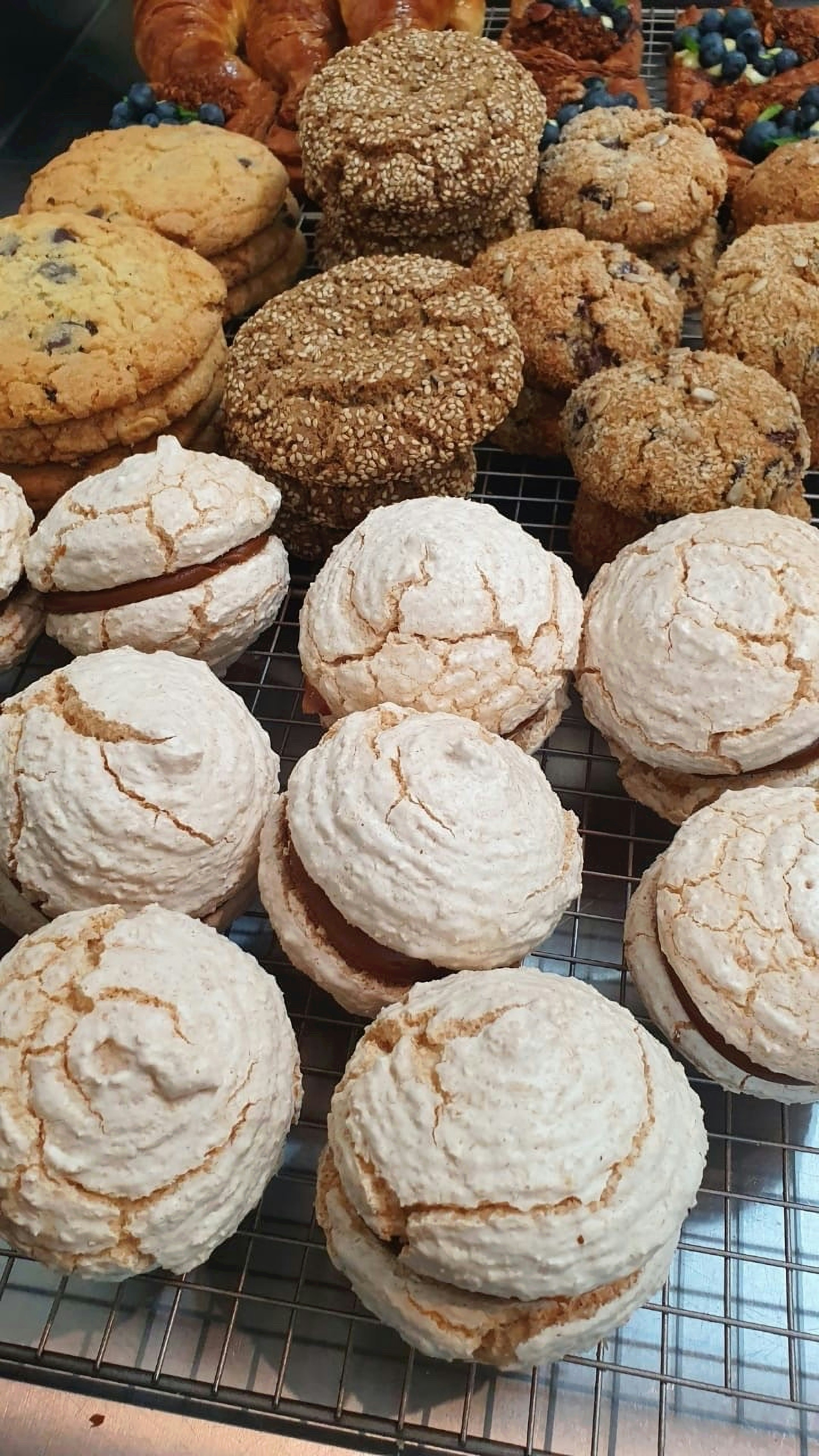 A close up of a variety of different cookies and confections at Atelier Fuerza, laid out on a cooling rack.