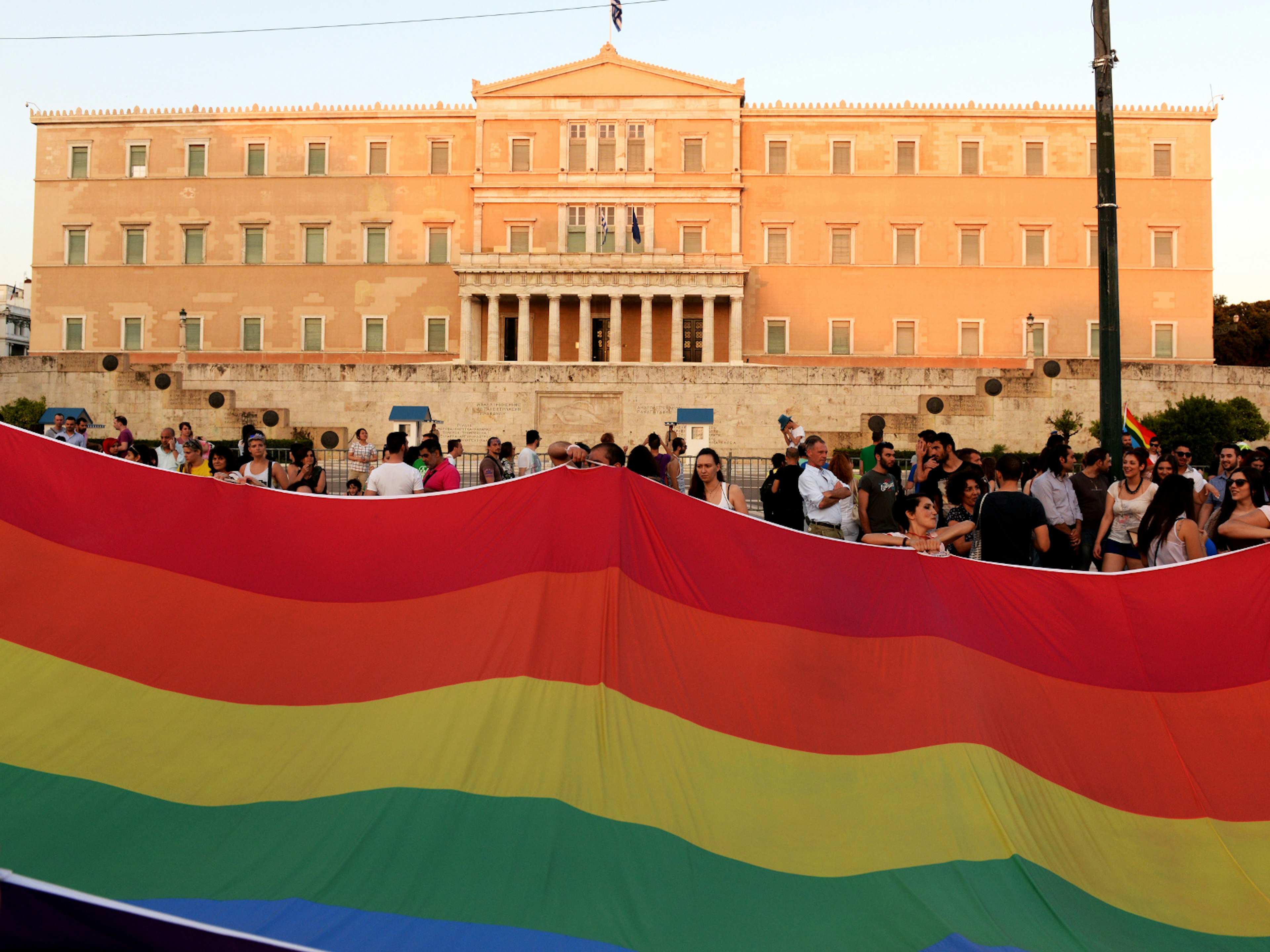 A huge rainbow flag in front of the Greek Parliament during the annual Pride parade © Kostas Koutsaftikis / Shutterstock