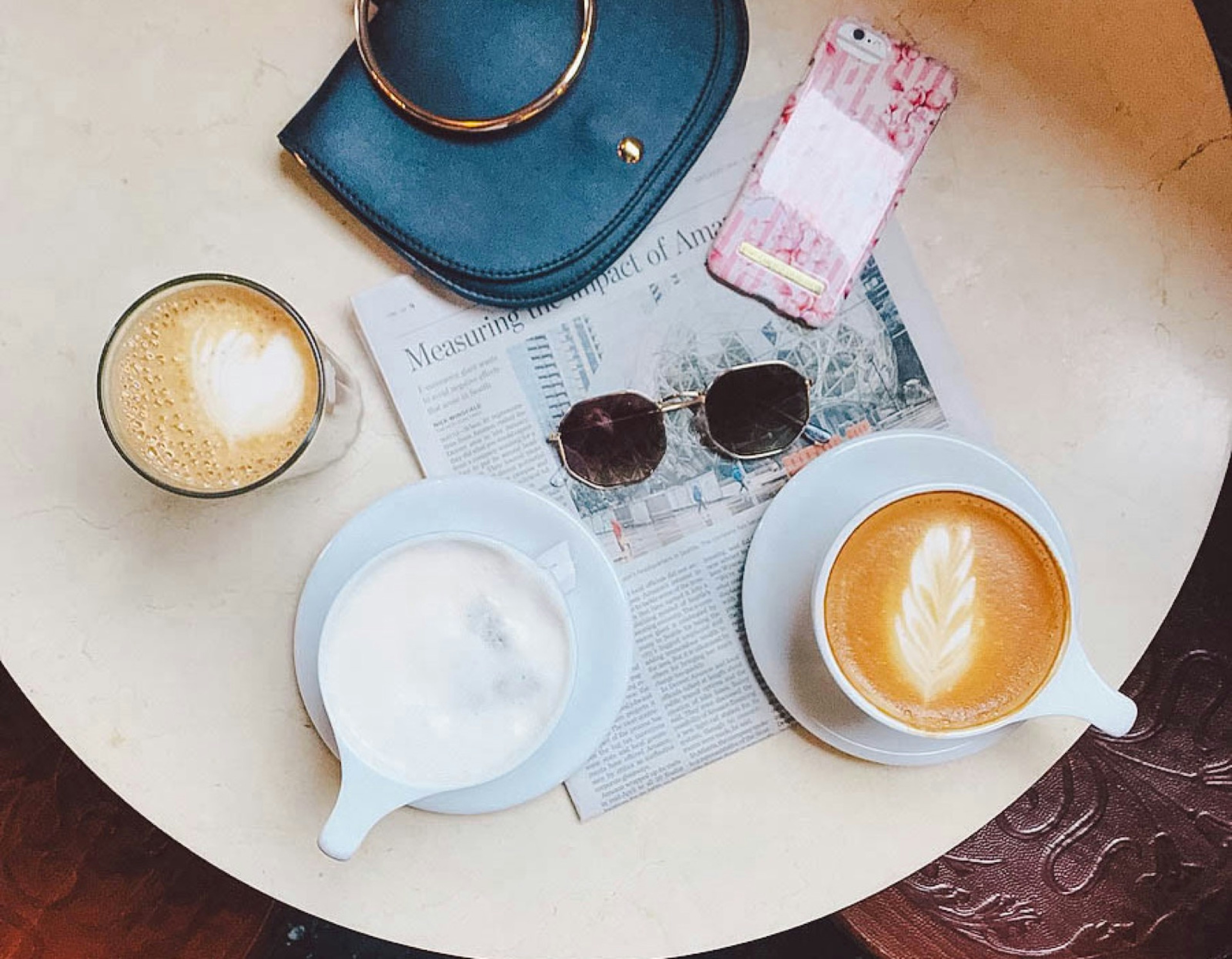 Mugs of coffee sit on a table along with a purse, sunglasses and a newspaper © Jessica Lam / ϰϲʿ¼