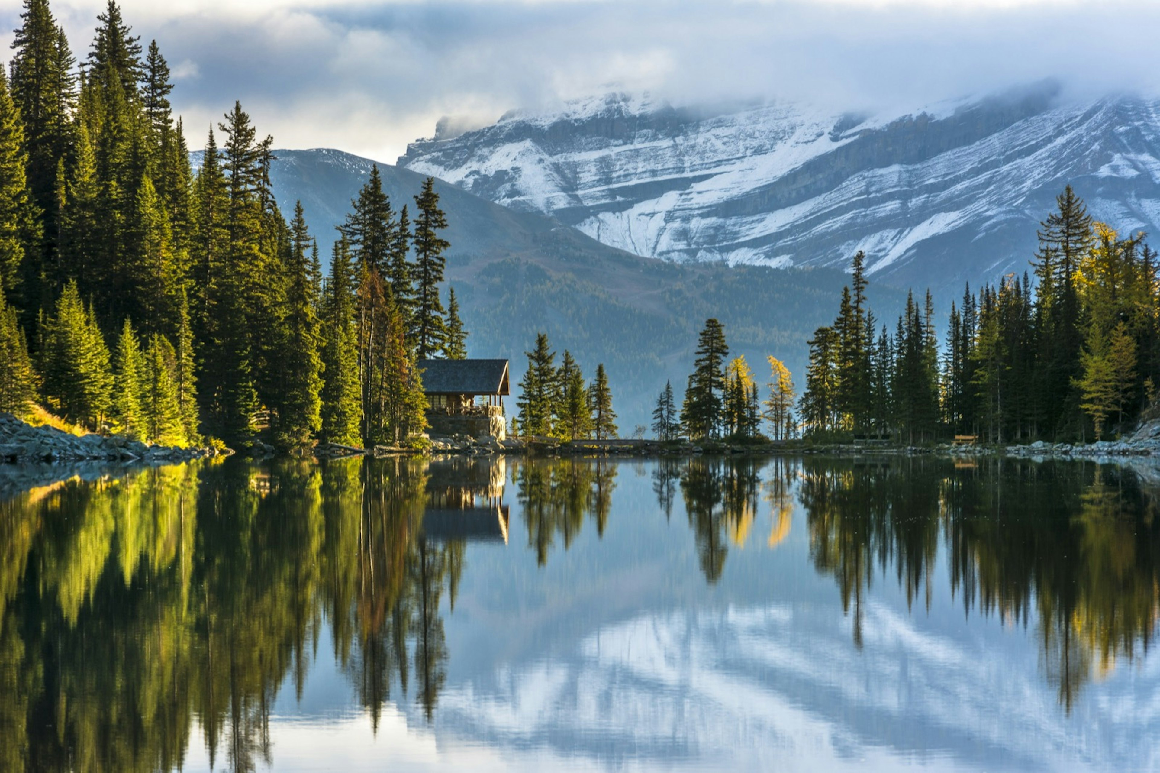 Reflection of the trees and the tea house at Lake Agnes in Banff National Park