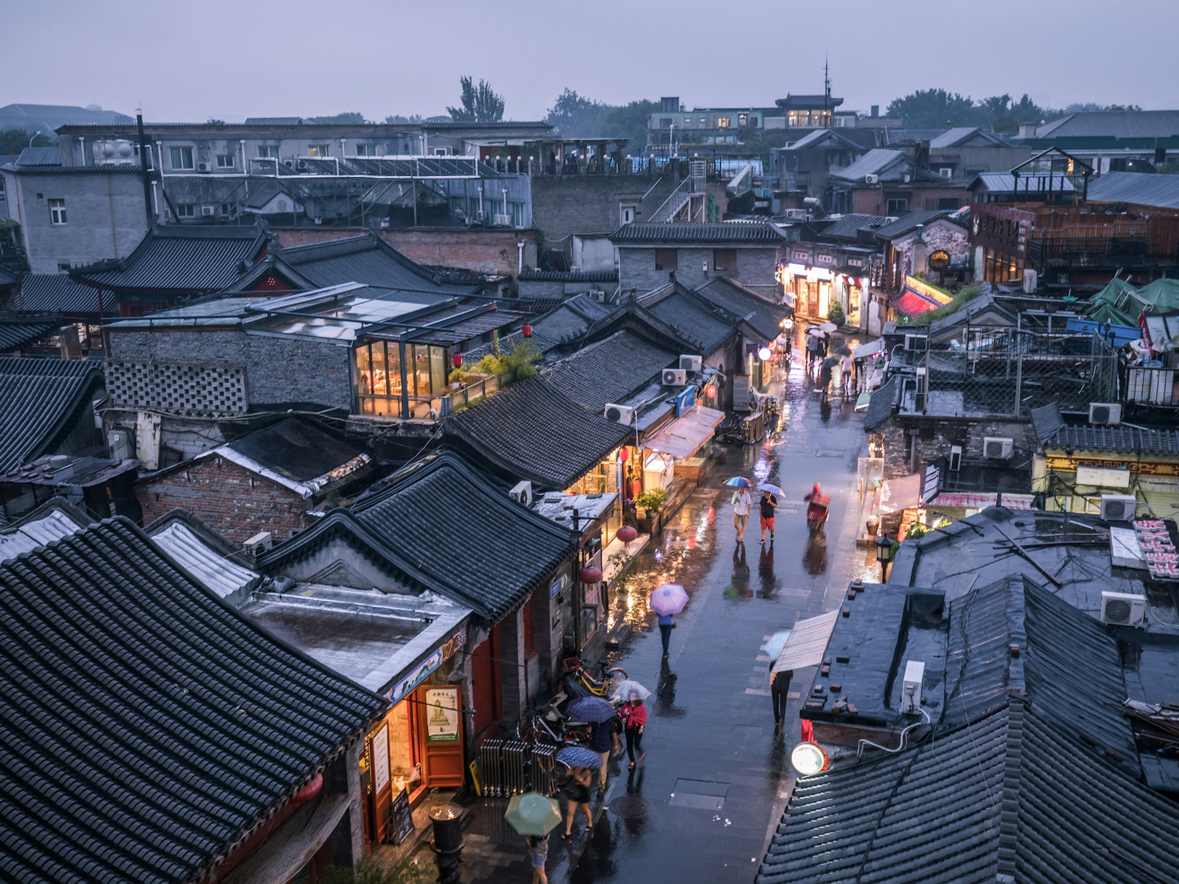 People walking down one of Beijing's historic hutong alleyways