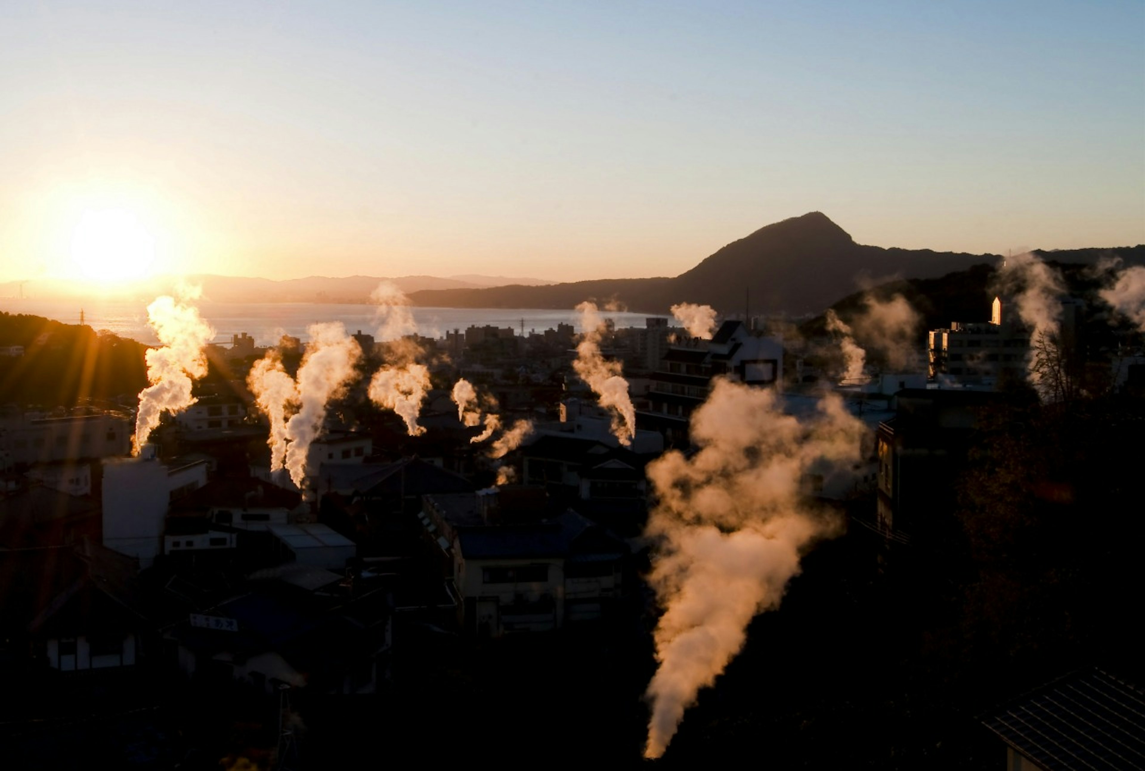 Steam rising from Beppu City at sunrise