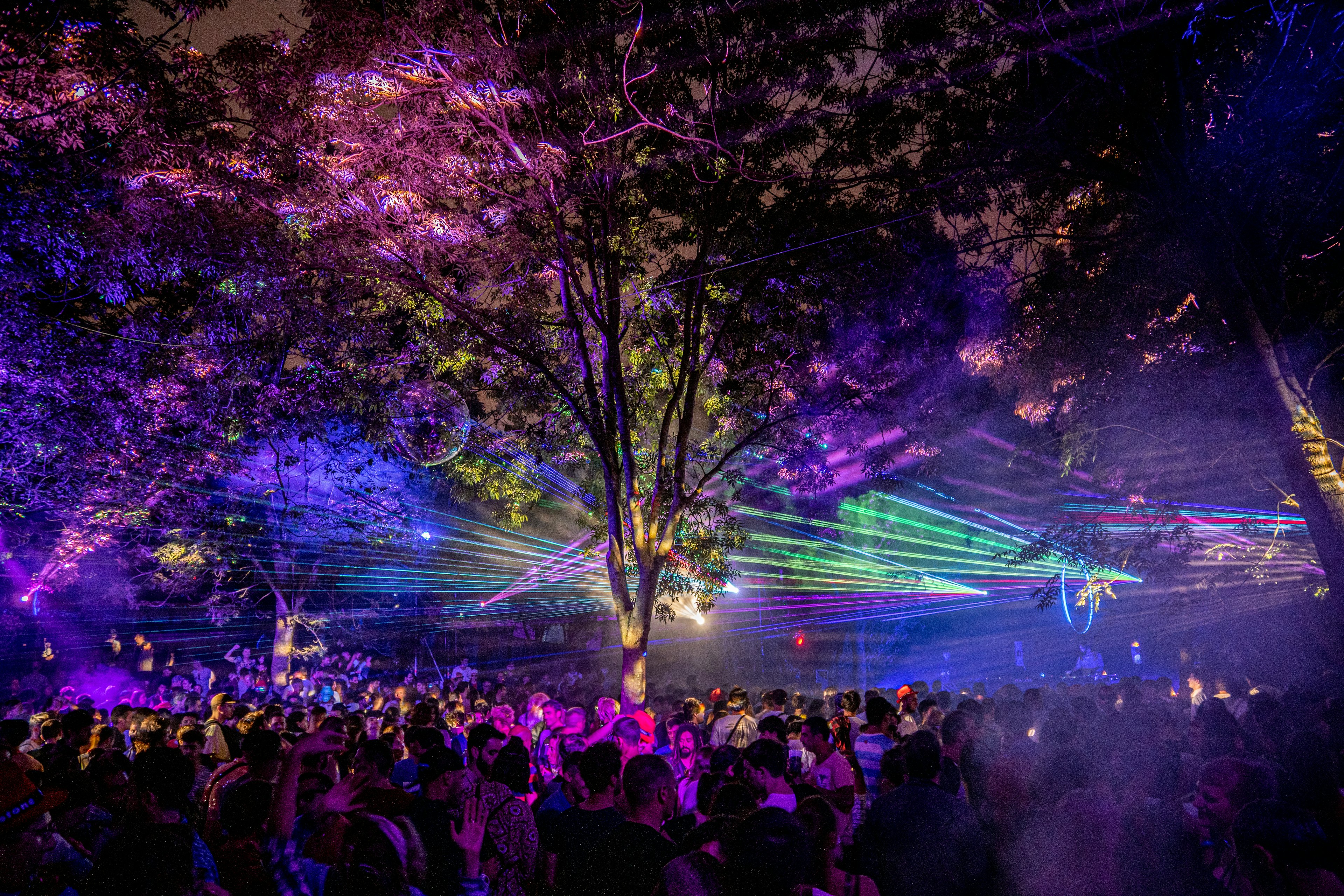 A laser light show takes place over the heads of a crowd dancing to a night-time electronic music set at Bilbao BKK Live festival.