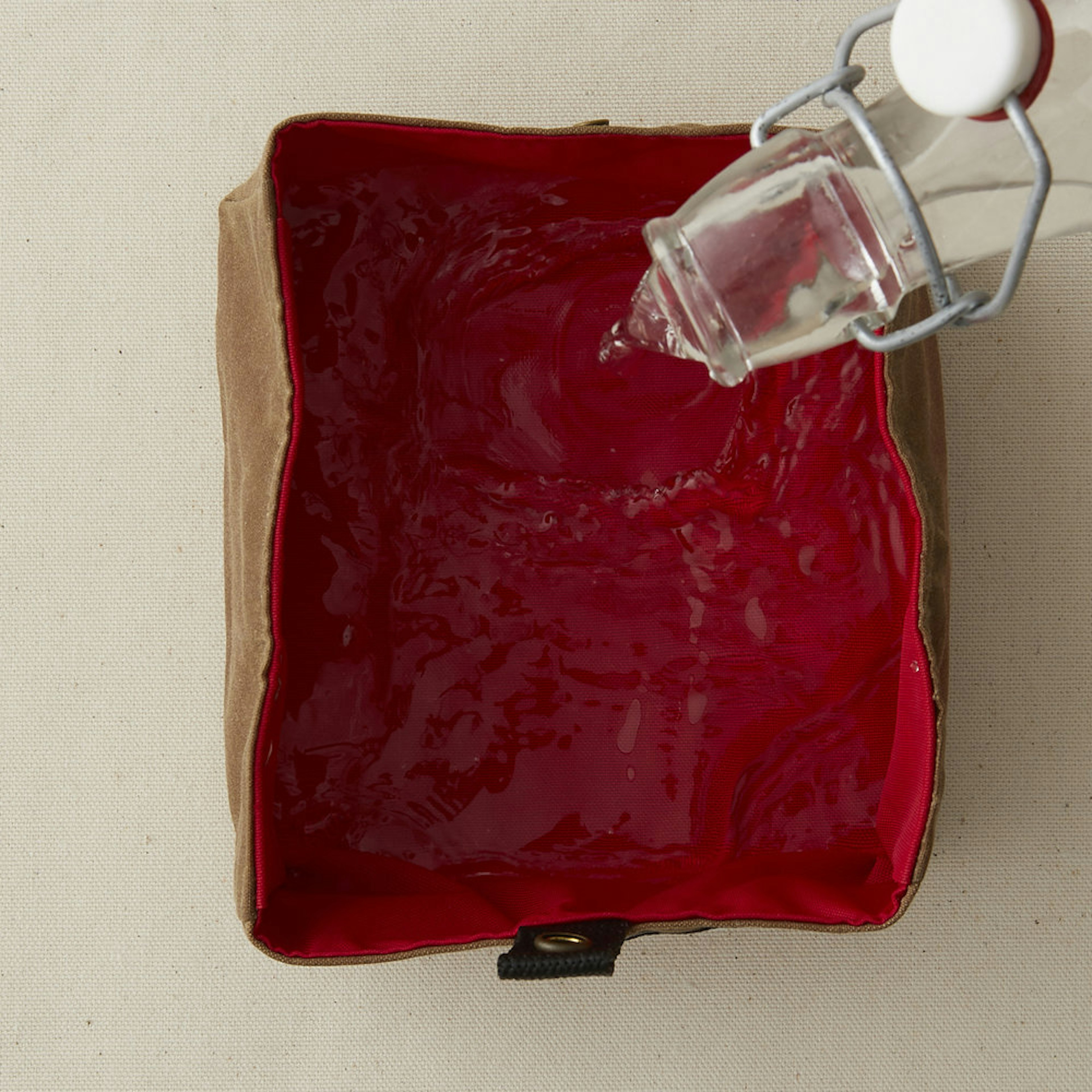 A bottle pouring water into the Dash bowl from Billy Wolf