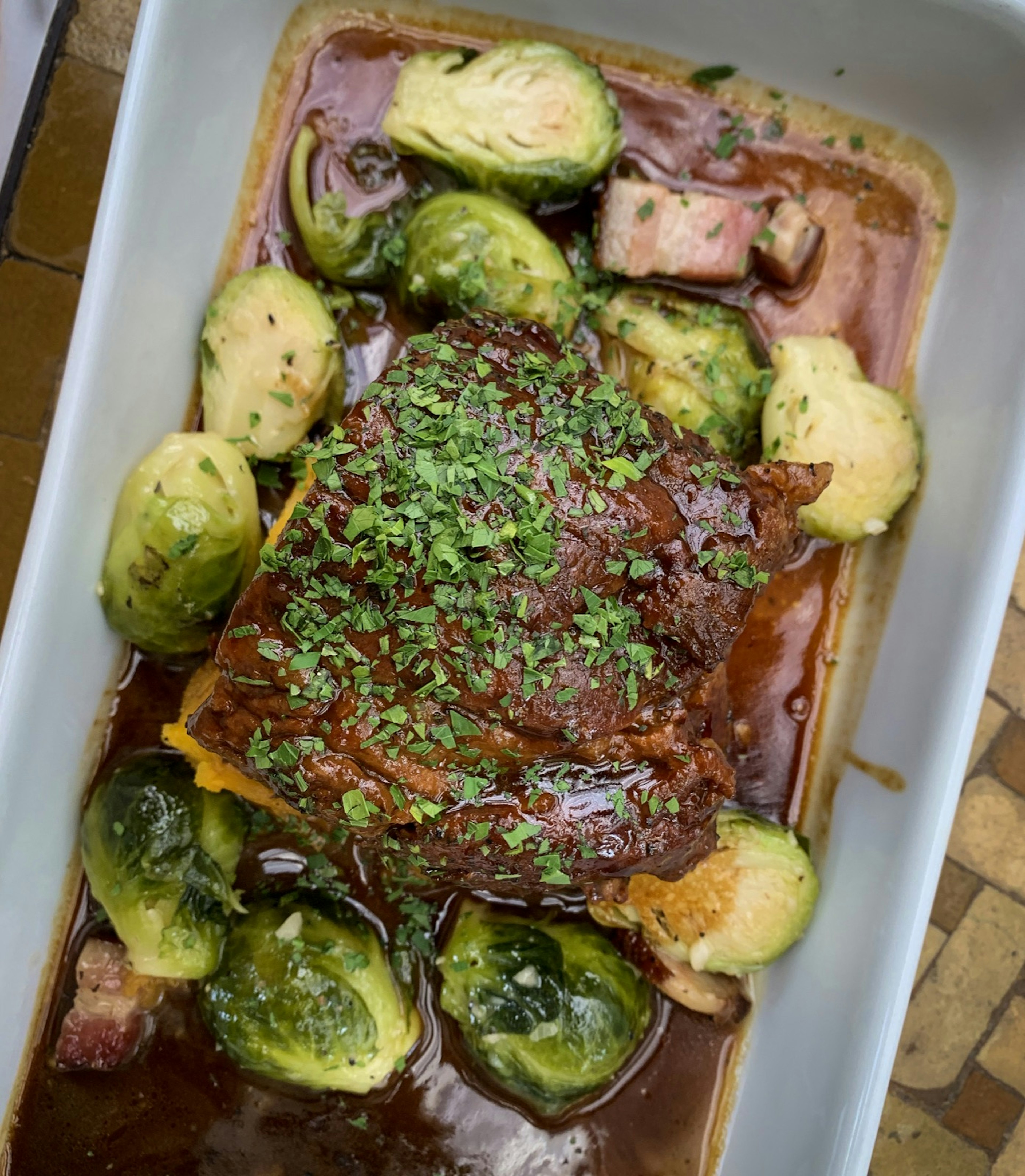 An overhead shot of a pork shoulder with brussels sprouts; weekend in Napa