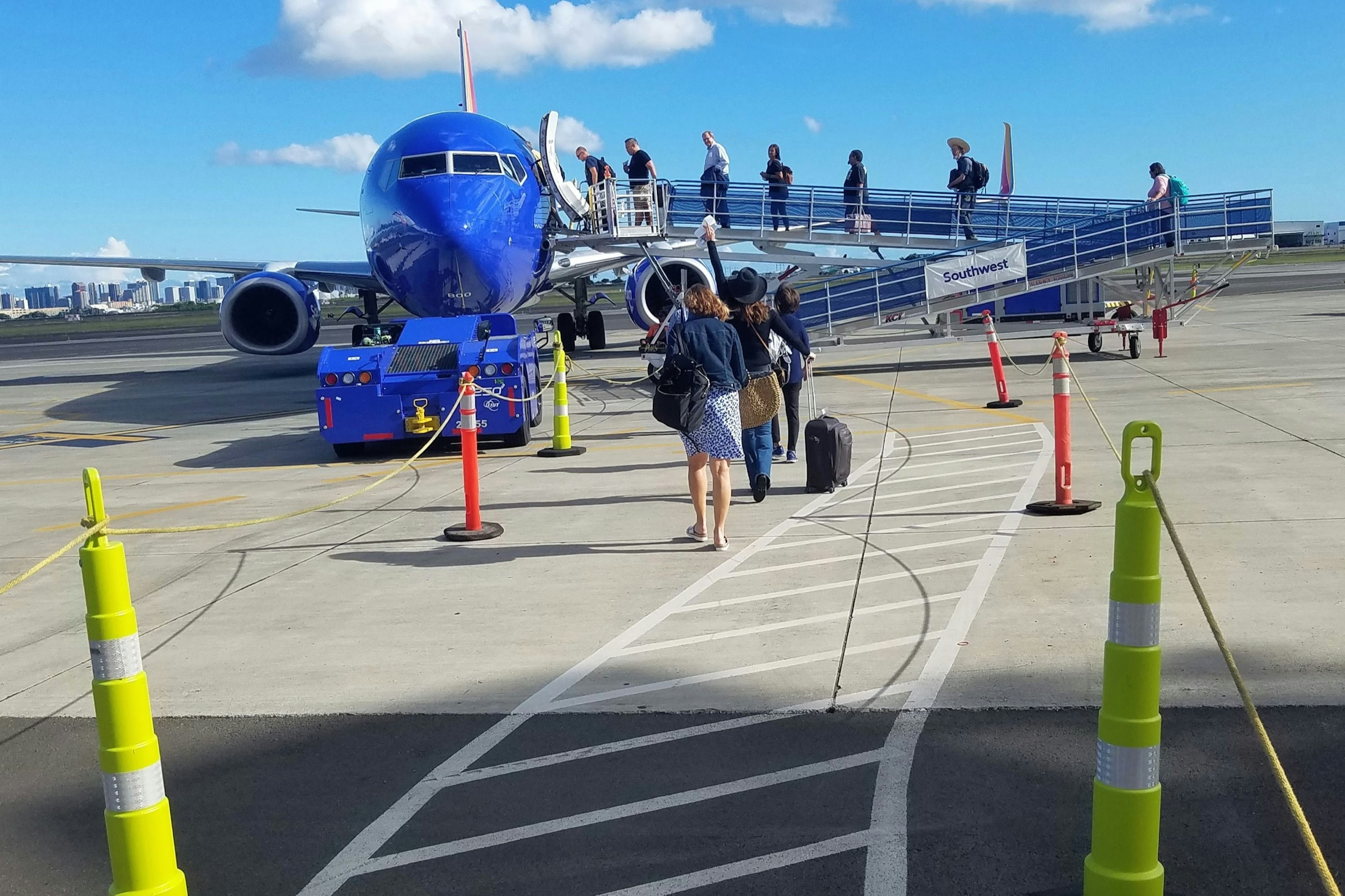 Using old-fashioned ramps that are exposed to the elements, passengers board a Southwest Airlines flight in a remote area of Honolulu’s Inouye International Airport.