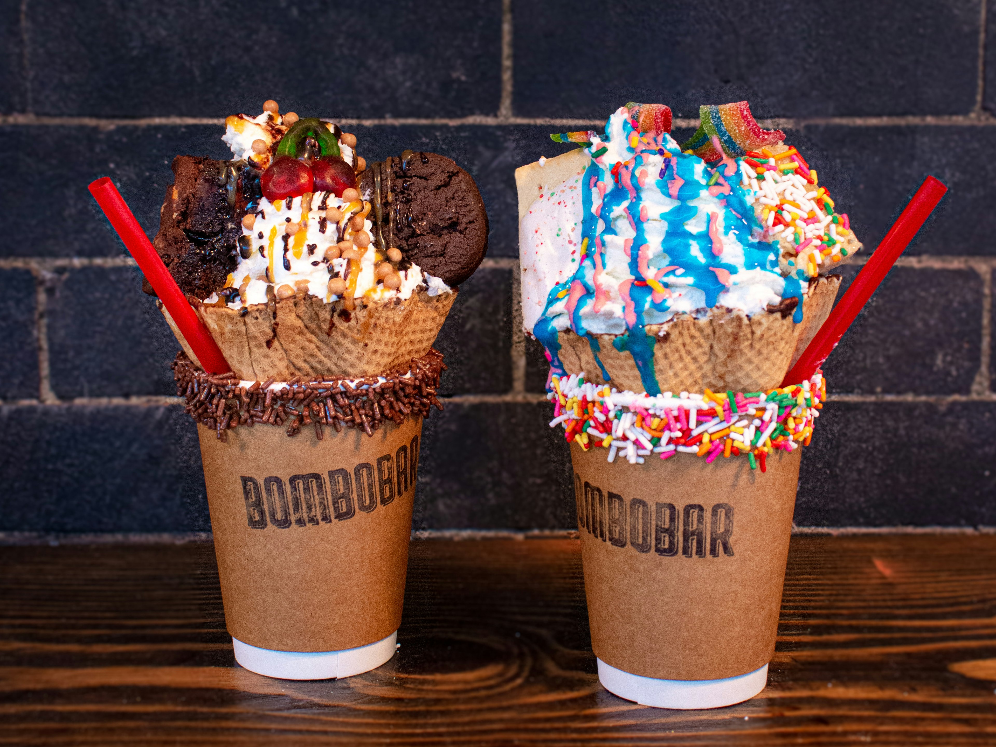 Two chocolate shakes topped with sprinkles and waffle cones