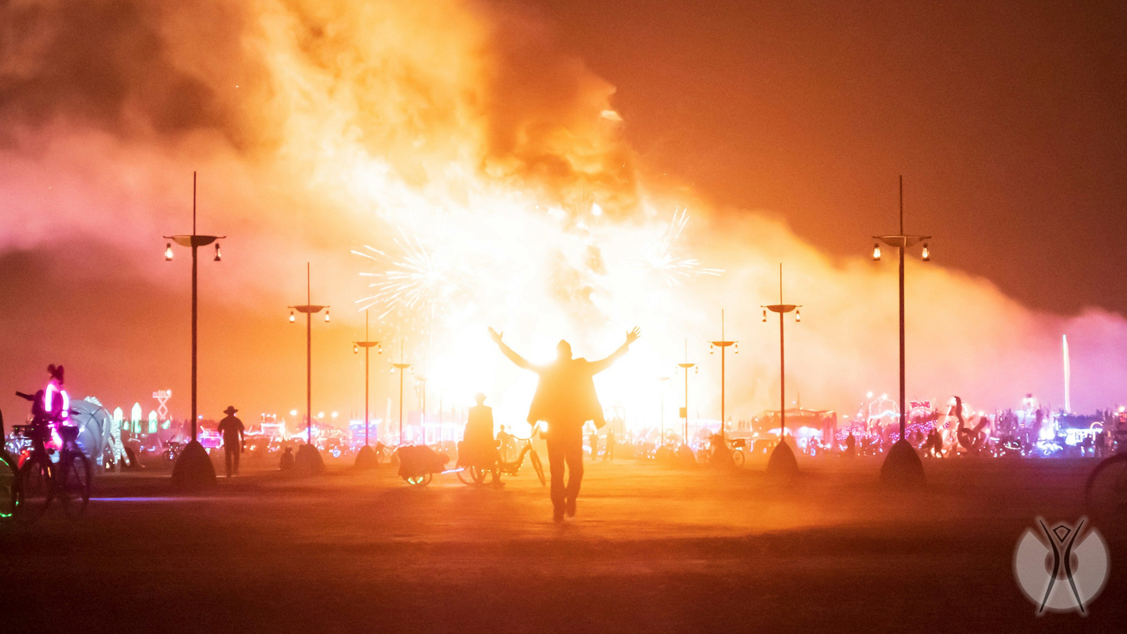 A man walks away from a burning art piece at Burning Man.