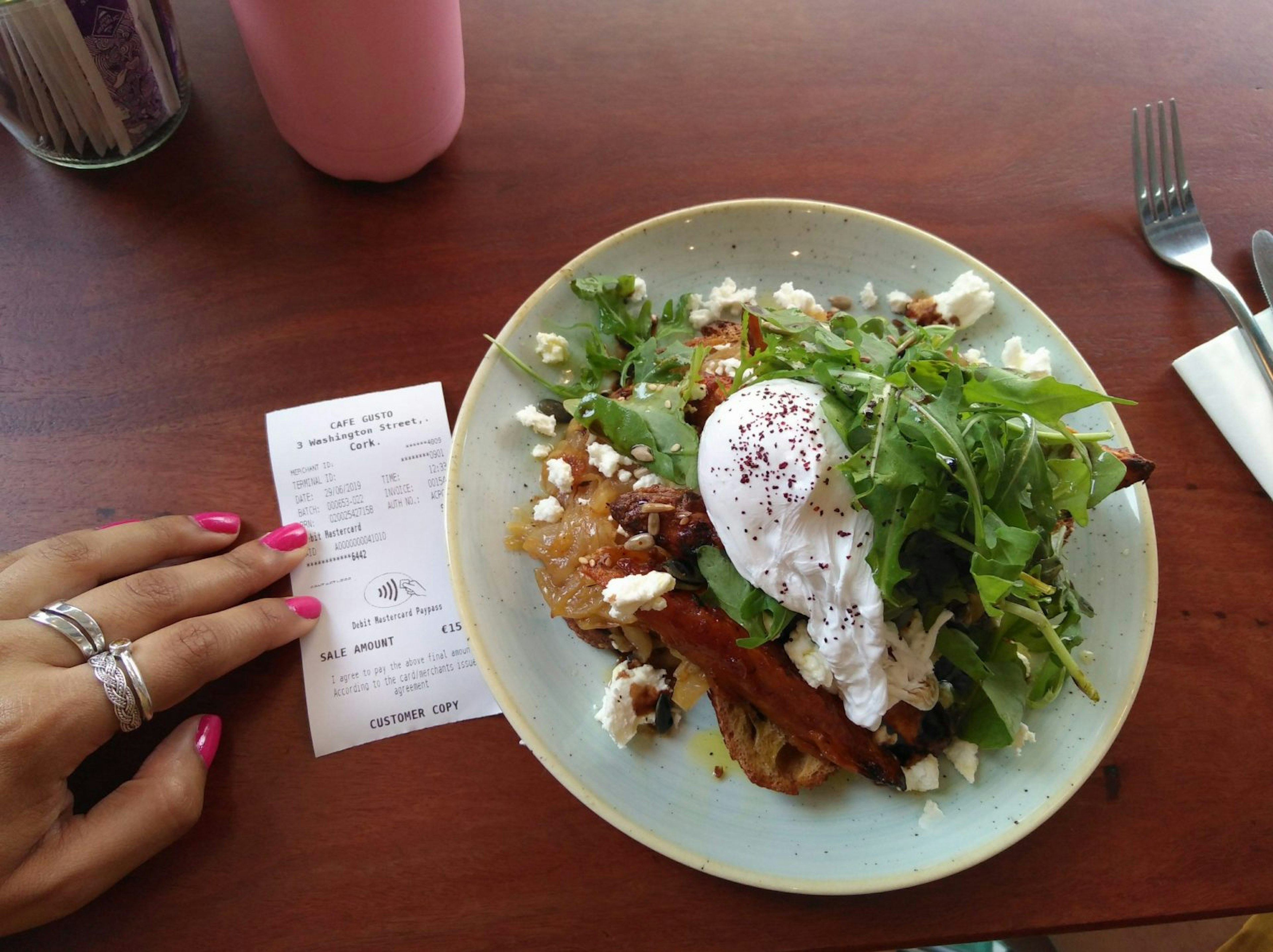 Poached egg, roasted sweet potato, caramelised onions and goats cheese on sourdough toast, with the receipt next to it.