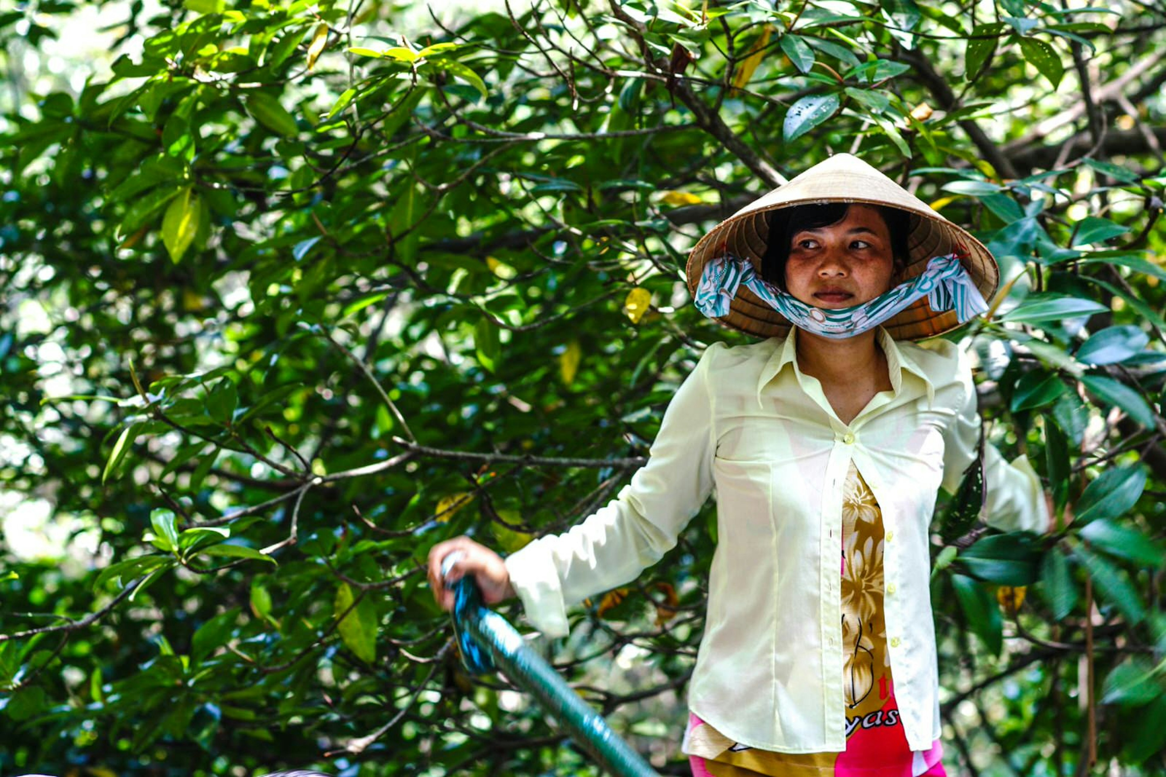 A woman punts a boat on Can Gio; best day trips from Ho Chi Minh City