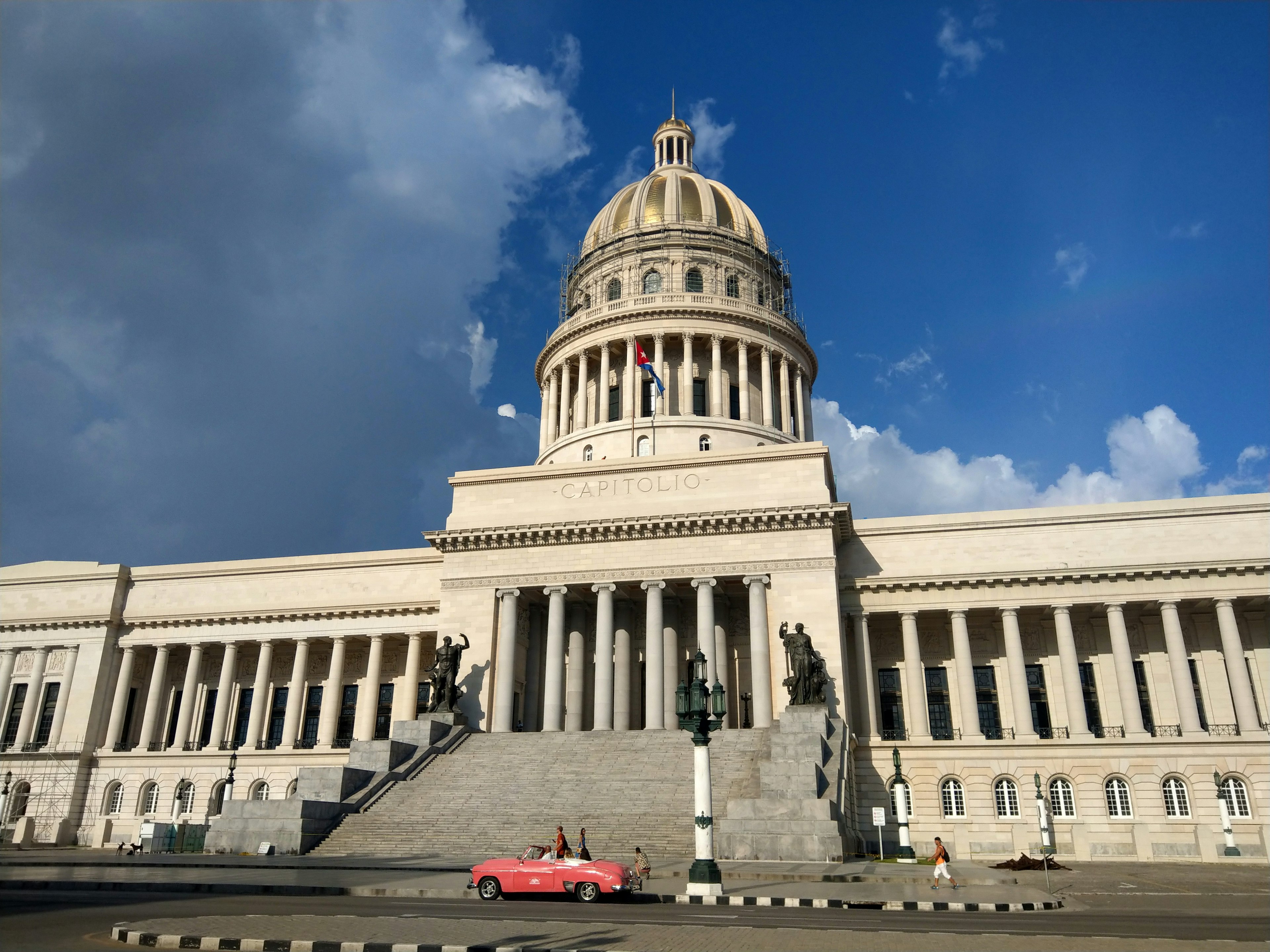 A hot pink classic car is parked in front of the newly renovated Capitolio Nacional; Havana historic sites